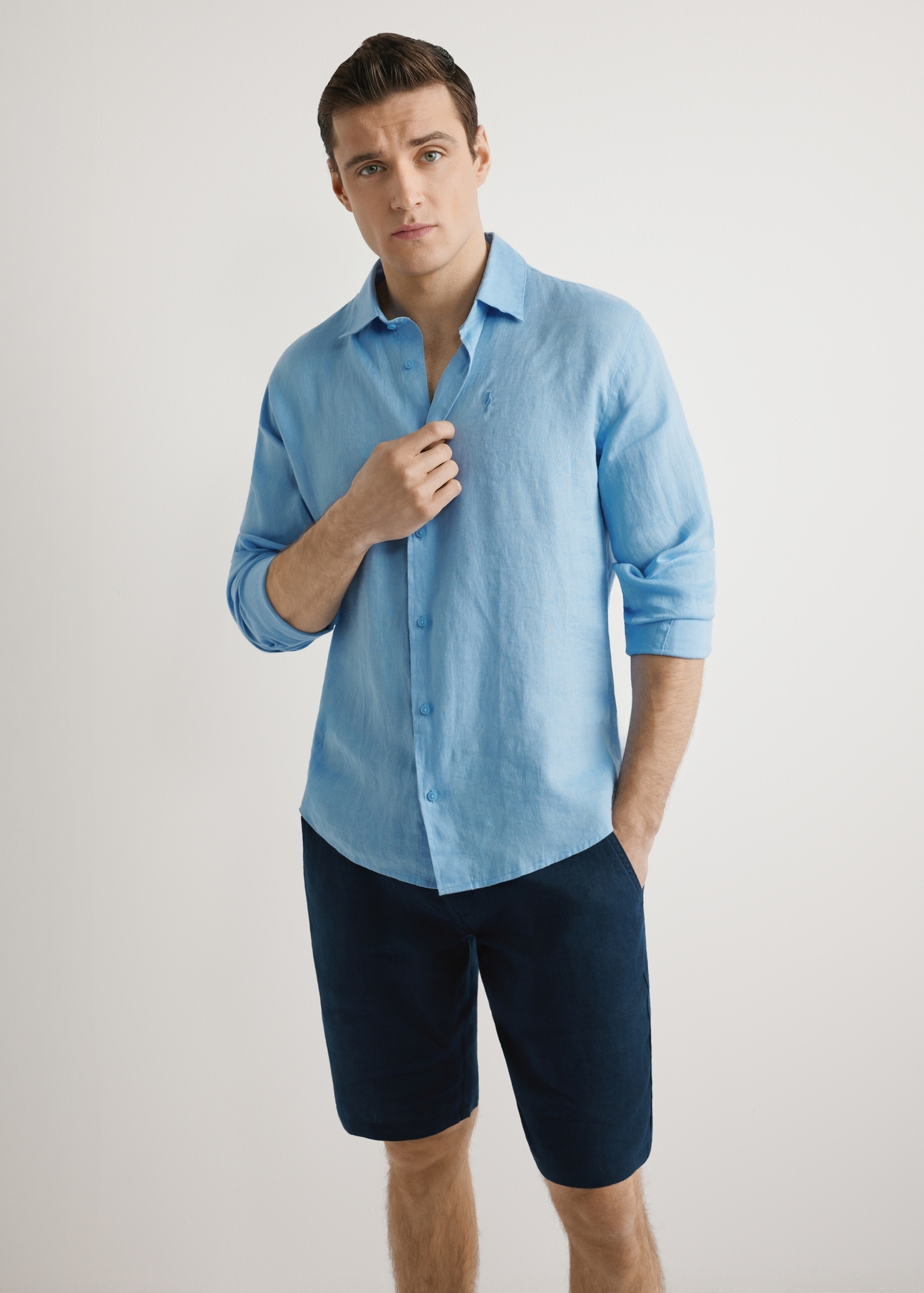 Niebieska lniana koszula męska KOSMT-0321A-7B(W26),  widok produktu z przodu, na modelu, na jasnym tle. Widoczna połowa sylwetki. 