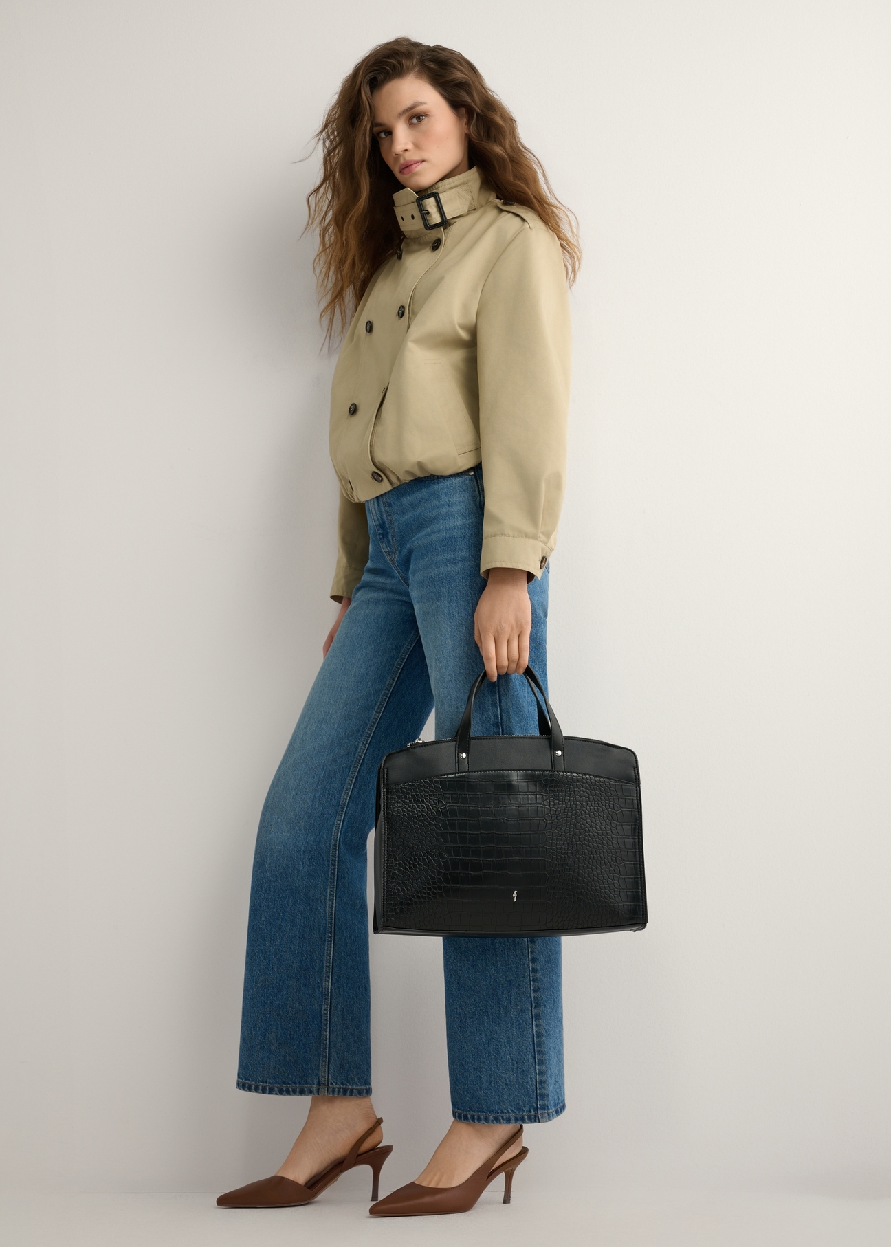 Czarna torba damska croco TOREC-1143-9G(W26), widok produktu w dłoni modelki. Widoczna cała sylwetka.