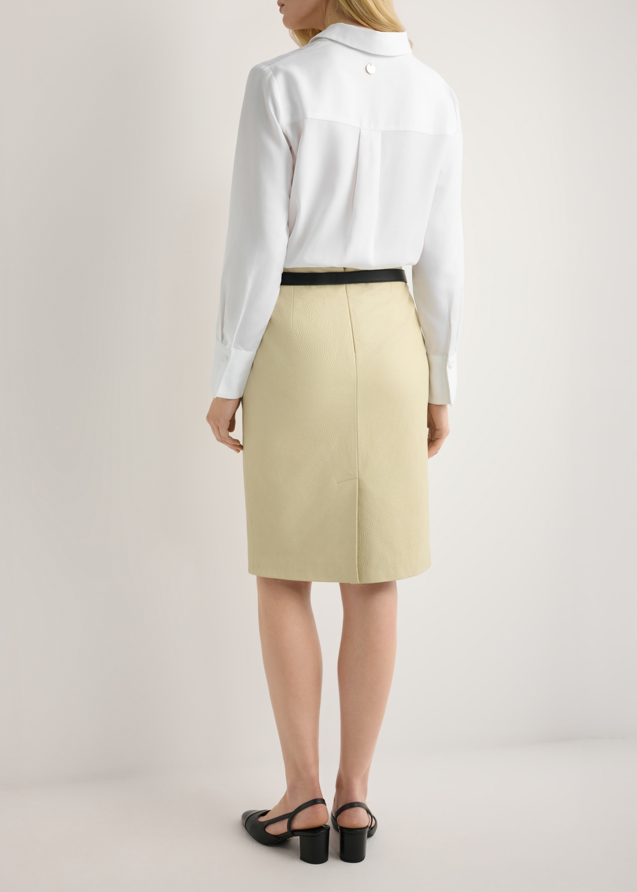 Skórzana spódnica w kolorze żółtym SPCDS-0031-2A(W26), widok produktu z tyłu na modelce. Widoczna połowa sylwetki.