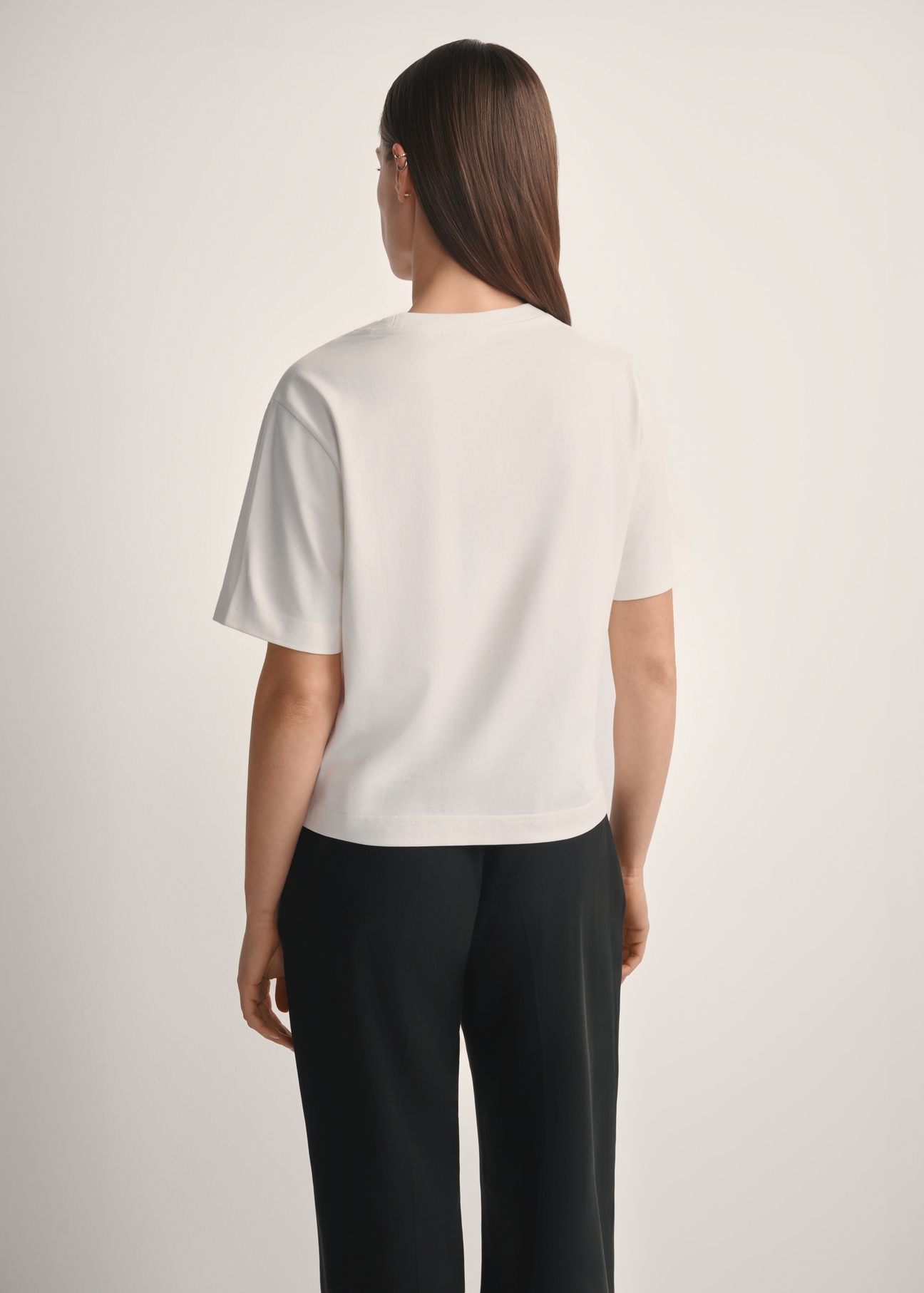 Bawełniany kremowy T-shirt damski TSHDT-0138-0B(W26), widok produktu od tyłu na modelce, widoczna połowa sylwetki.