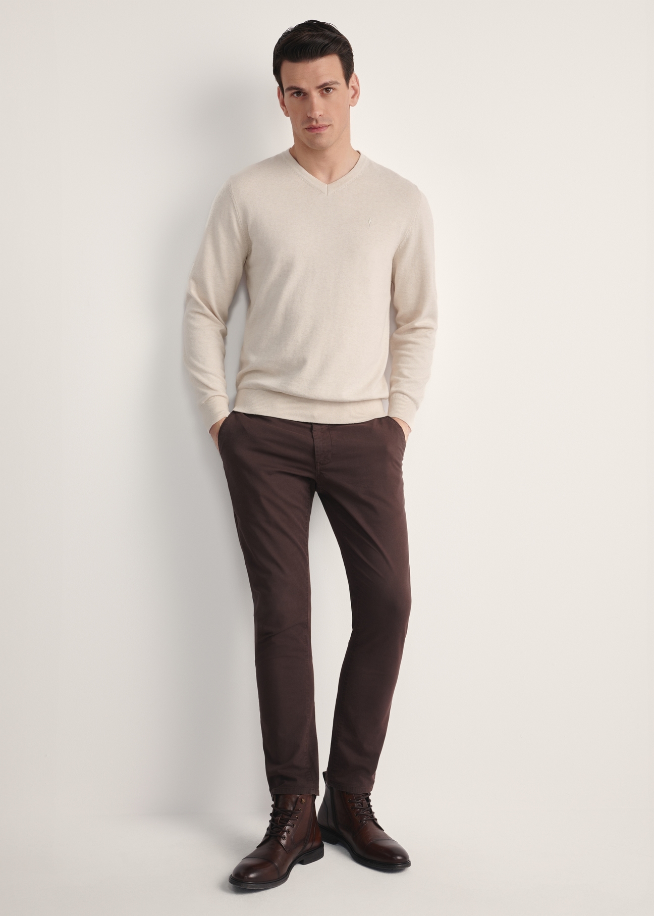 Beżowy sweter męski z logo SWEMT-0159A-80(Z25) - widok produktu z przodu na modelu na białym tle. Widoczna cała sylwetka. 