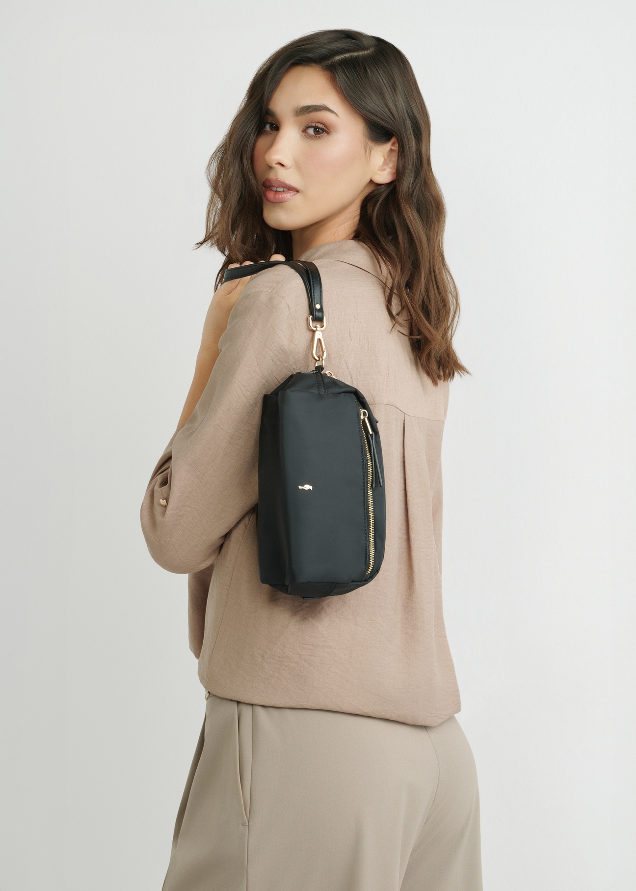 Czarna kosmetyczka damska TOREN-0347-99(W26), widok produktu na sylwetce modelki, na jasnym tle.