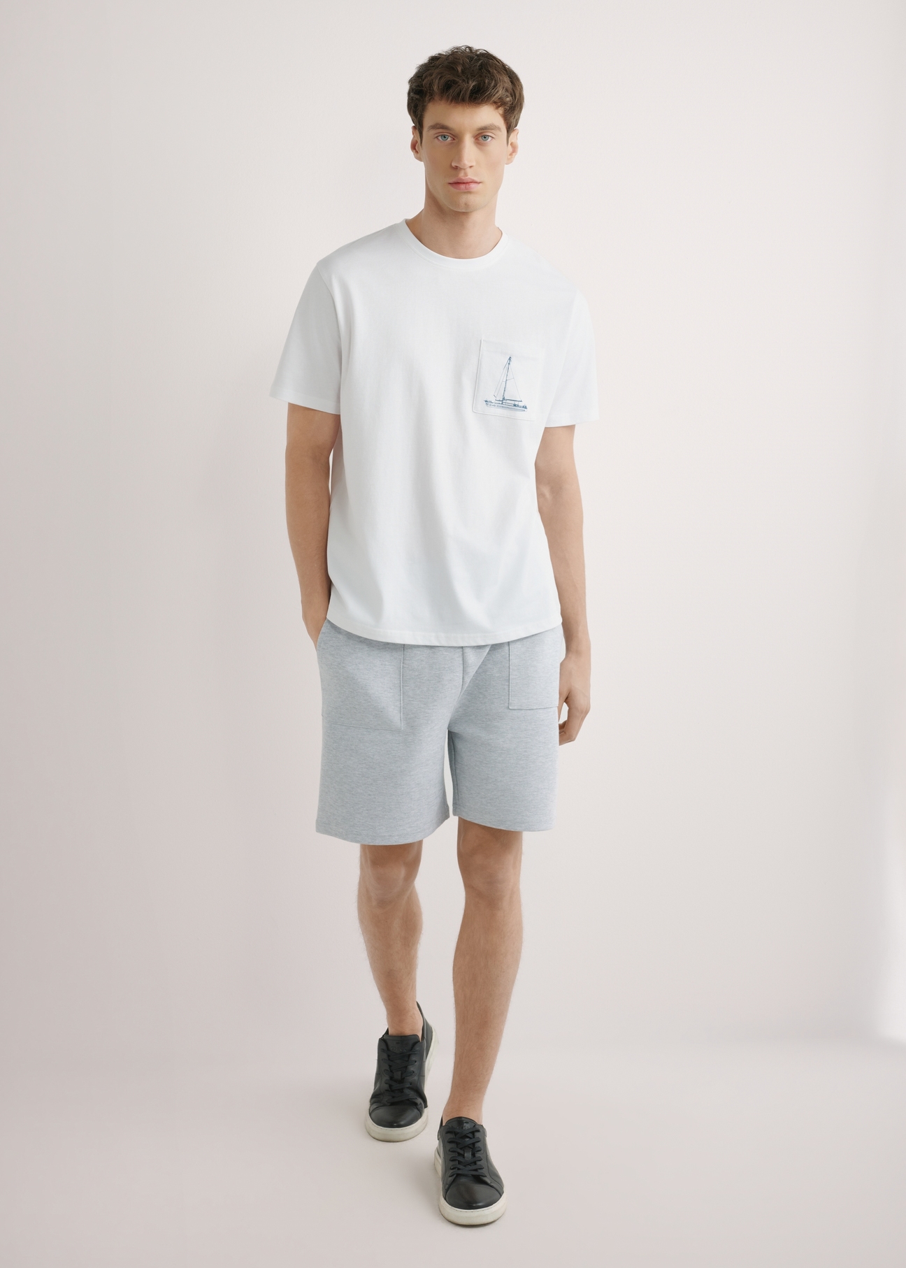 Biały T-shirt męski z nadrukiem TSHMT-0145-0A(W26), widok produktu z przodu na modelu. Widoczna cała sylwetka.