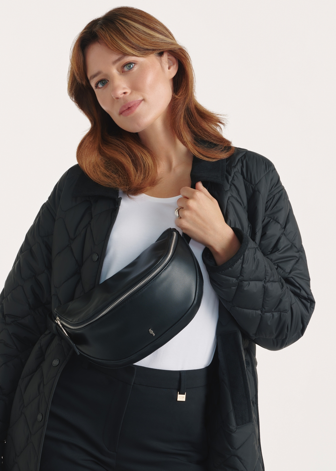 Czarna torebka damska TOREC-1050-99(Z25), widok produktu przodem na modelce, widoczne pół sylwetki.