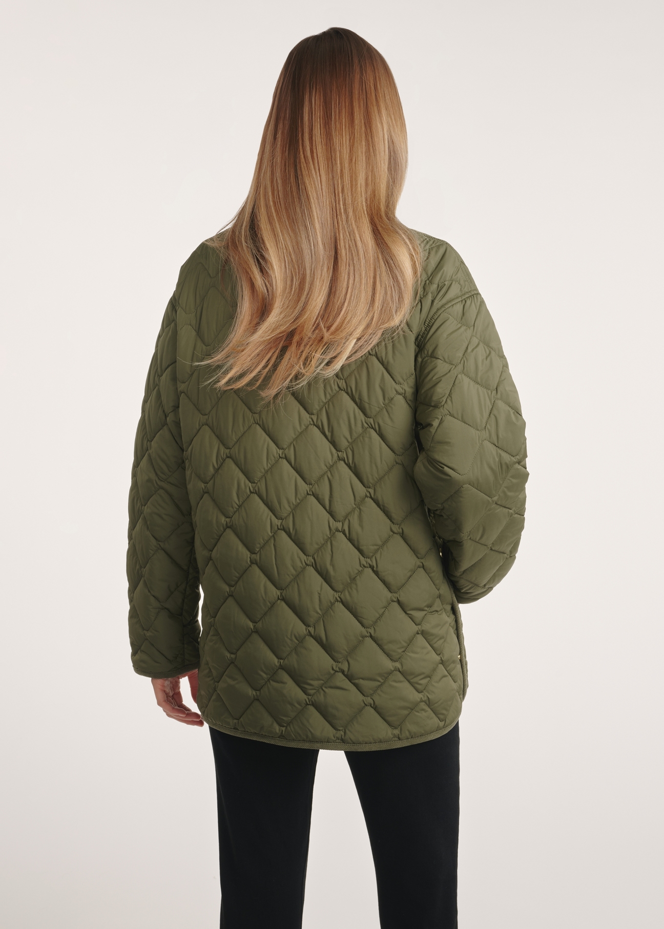 Kurtka damska z kołnierzem w kolorze khaki KURDT-0596-55(Z25), widok produktu z tyłu na modelce. Widoczna połowa sylwetki.