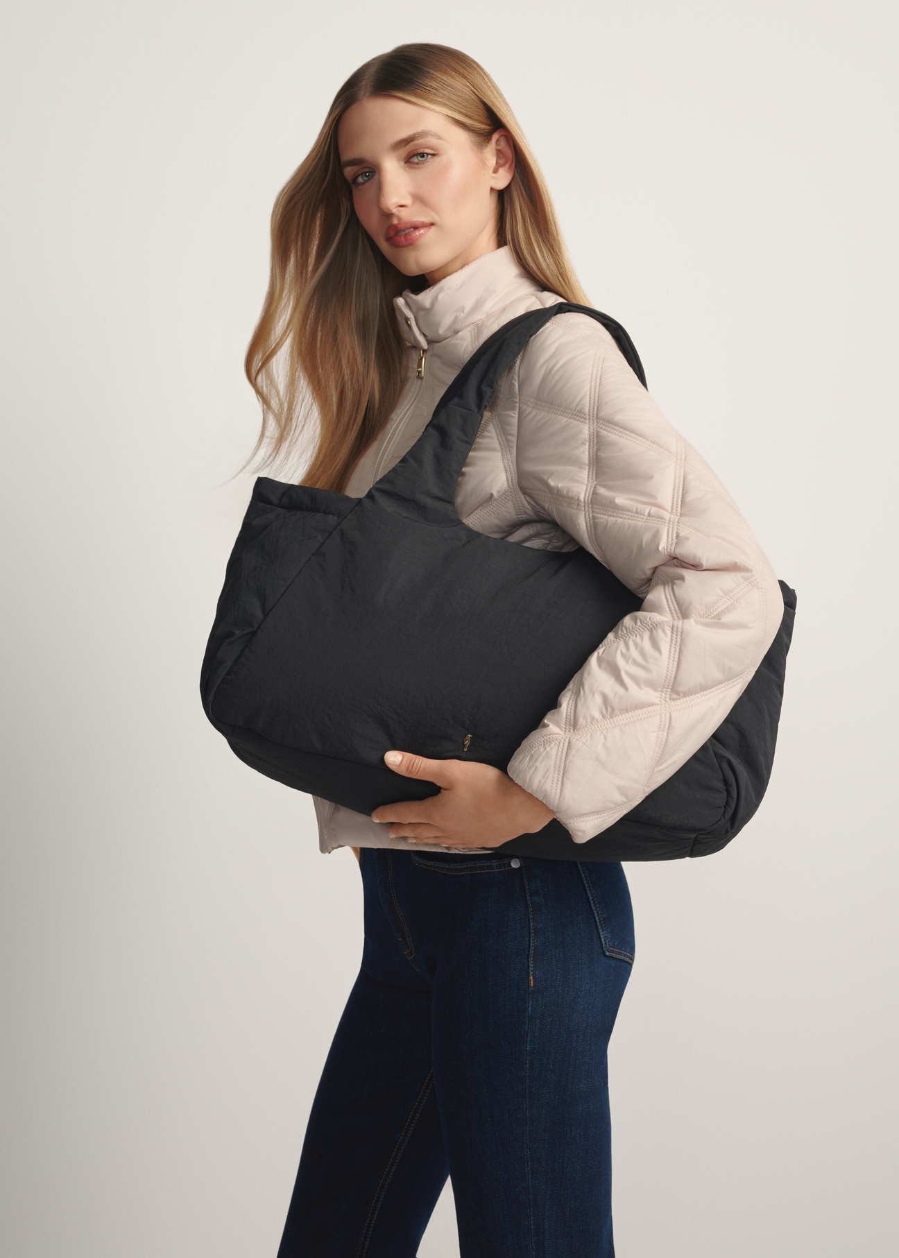 Czarna torebka shopper damska TOREN-0336-99(W26) - widok produktu z boku, na modelce, na jasnym tle. Widoczna połowa sylwetki.
