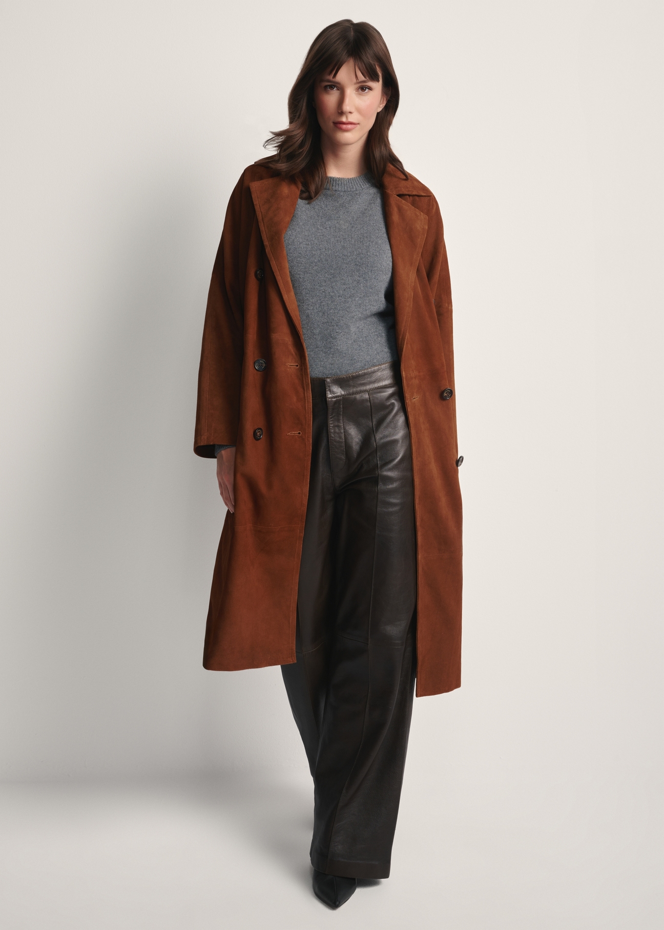 Brązowy zamszowy płaszcz damski oversize KURDS-0551-0775(Z25), widok produktu z przodu na modelce. Widoczna cała sylwetka.