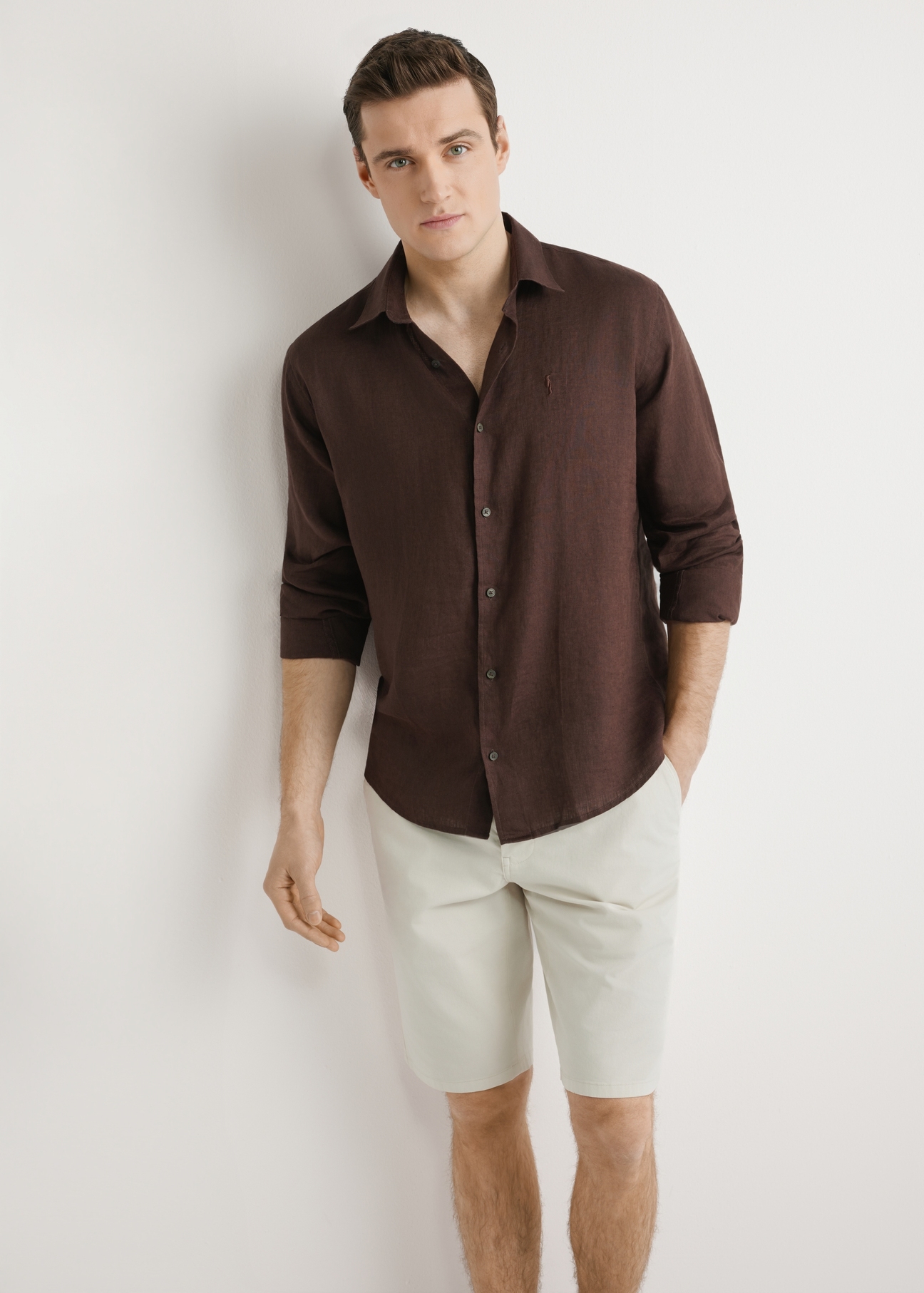 Brązowa lniana koszula męska KOSMT-0321A-1I(W26) - widok produktu z przodu, na modelu, na jasnym tle. Widoczna sylwetka do kolana. 