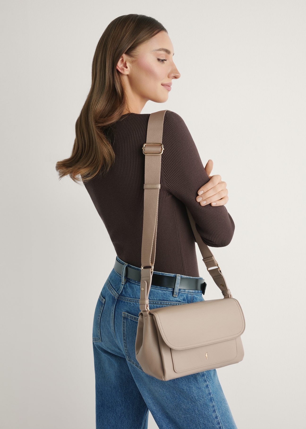 Beżowa klasyczna torebka damska TOREC-1124-1D(W26)- widok produktu z przodu, na modelce, na jasnym tle. Widoczna sylwetka do kolan.