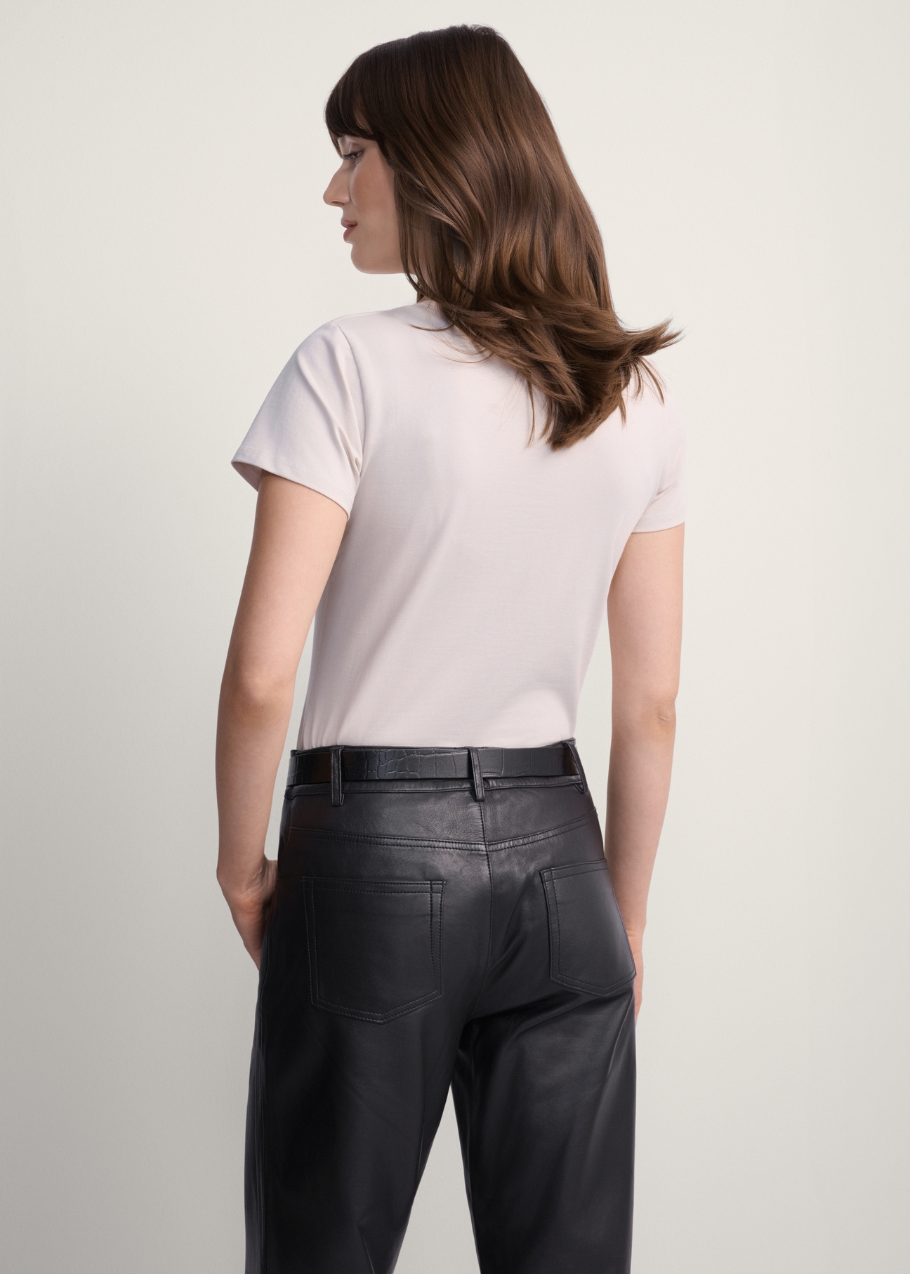 Beżowy T-shirt damski basic TSHDT-0111-81(KS), widok produktu z tyłu na modelce. Widoczna połowa sylwetki.