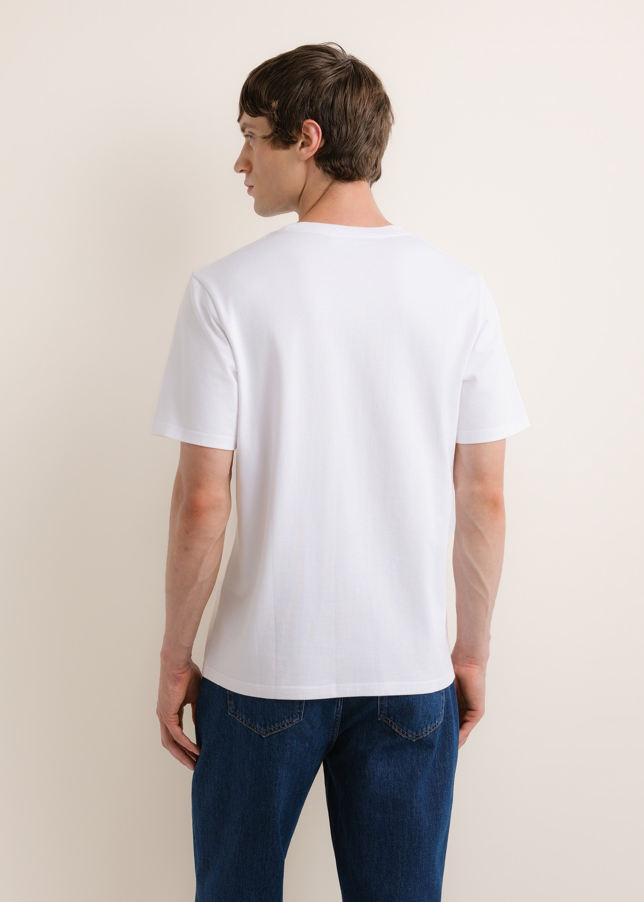 Biały bawełniany T-shirt męski TSHMT-0161-0A(Z26), widok produktu z tyłu na modelu. Widoczna połowa sylwetki.