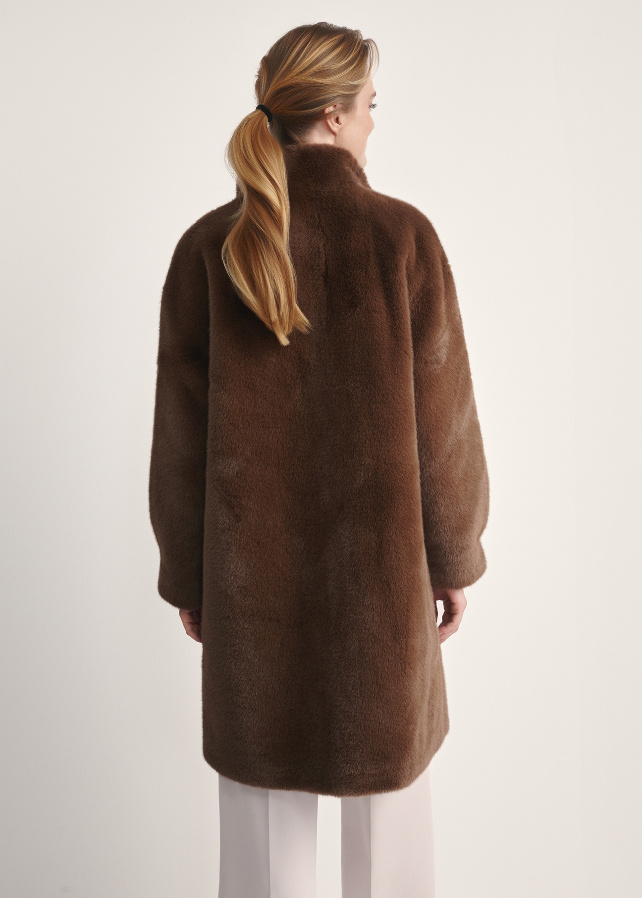 Brązowe eleganckie futro damskie FUTDP-0050-89(Z25), widok produktu od tyłu na modelce, widoczna połowa sylwetki.