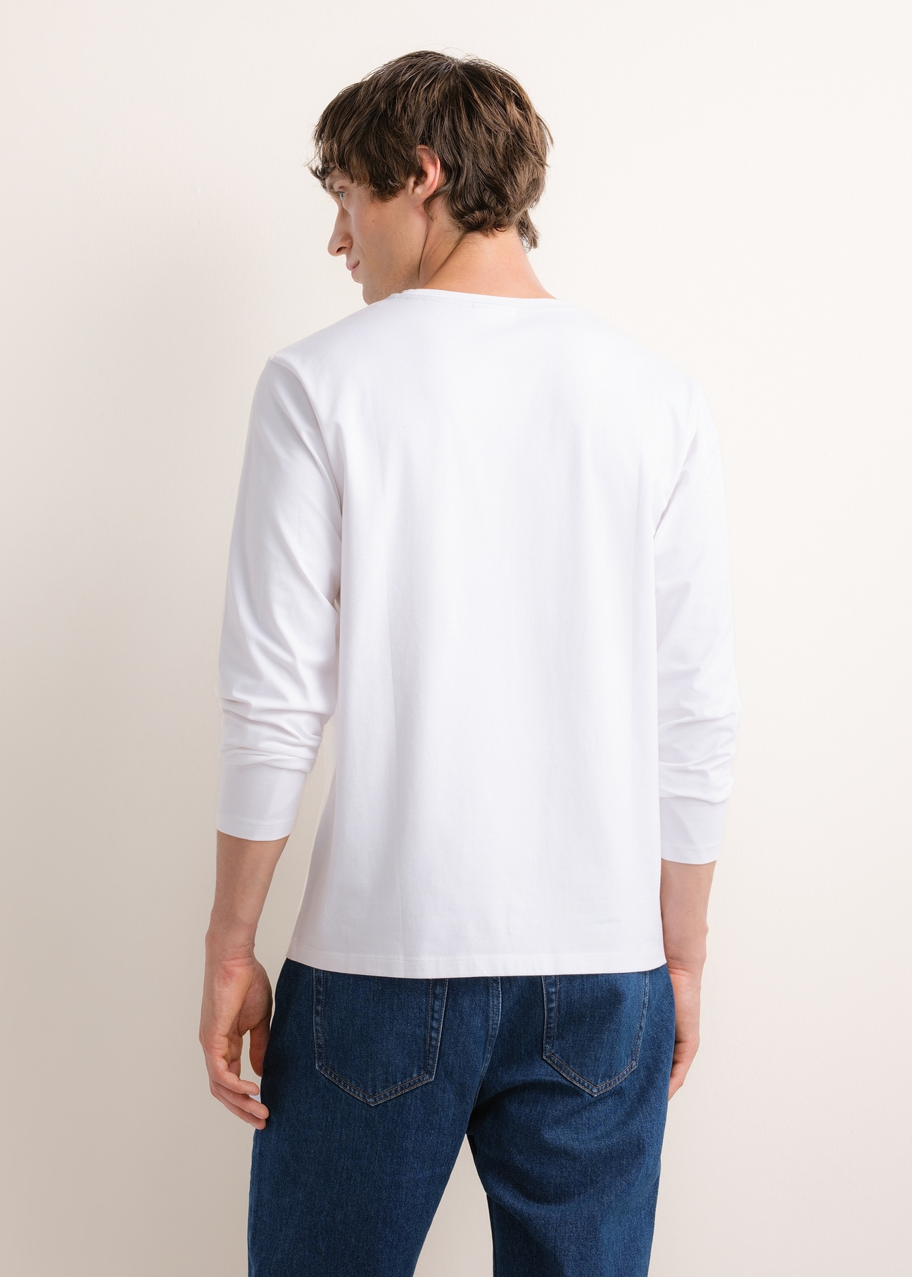 Biały longsleeve męski z nadrukiem LSLMT-0014-0A(Z26), widok produktu z tyłu na modelu. Widoczna cała sylwetka.