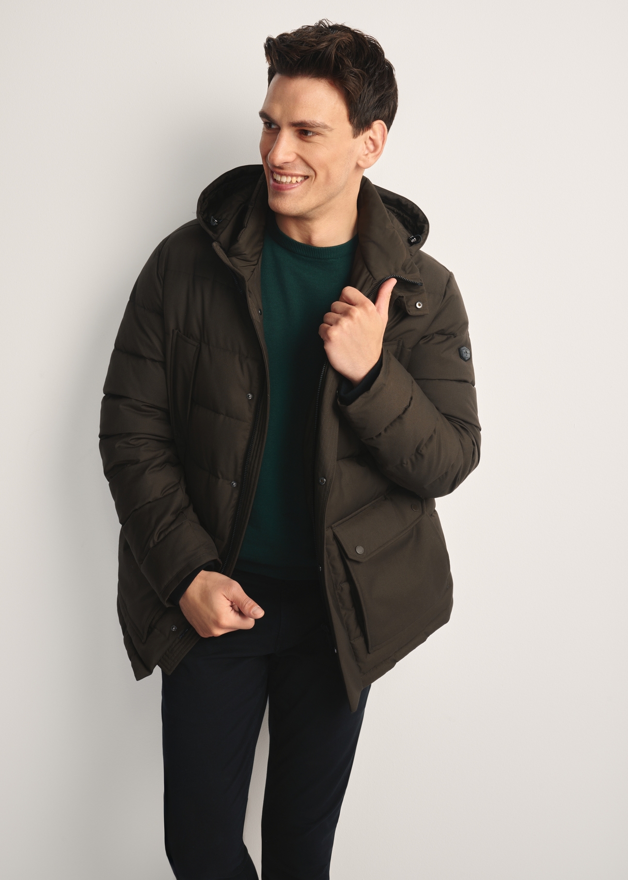 Oliwkowa zimowa kurtka męska KURMT-0379-57(Z25) - widok produktu z przodu na modelu na białym tle. Widoczna sylwetka do kolan.