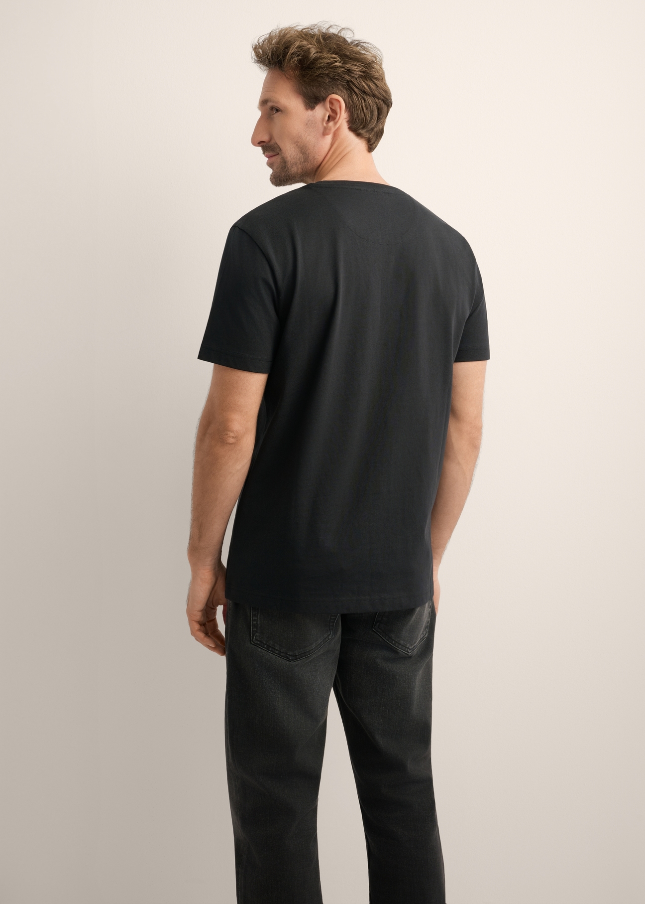 Czarny bawełniany T-shirt męski TSHMT-0154-99(Z26), widok produktu z tyłu na modelu. Widoczna połowa sylwetki.