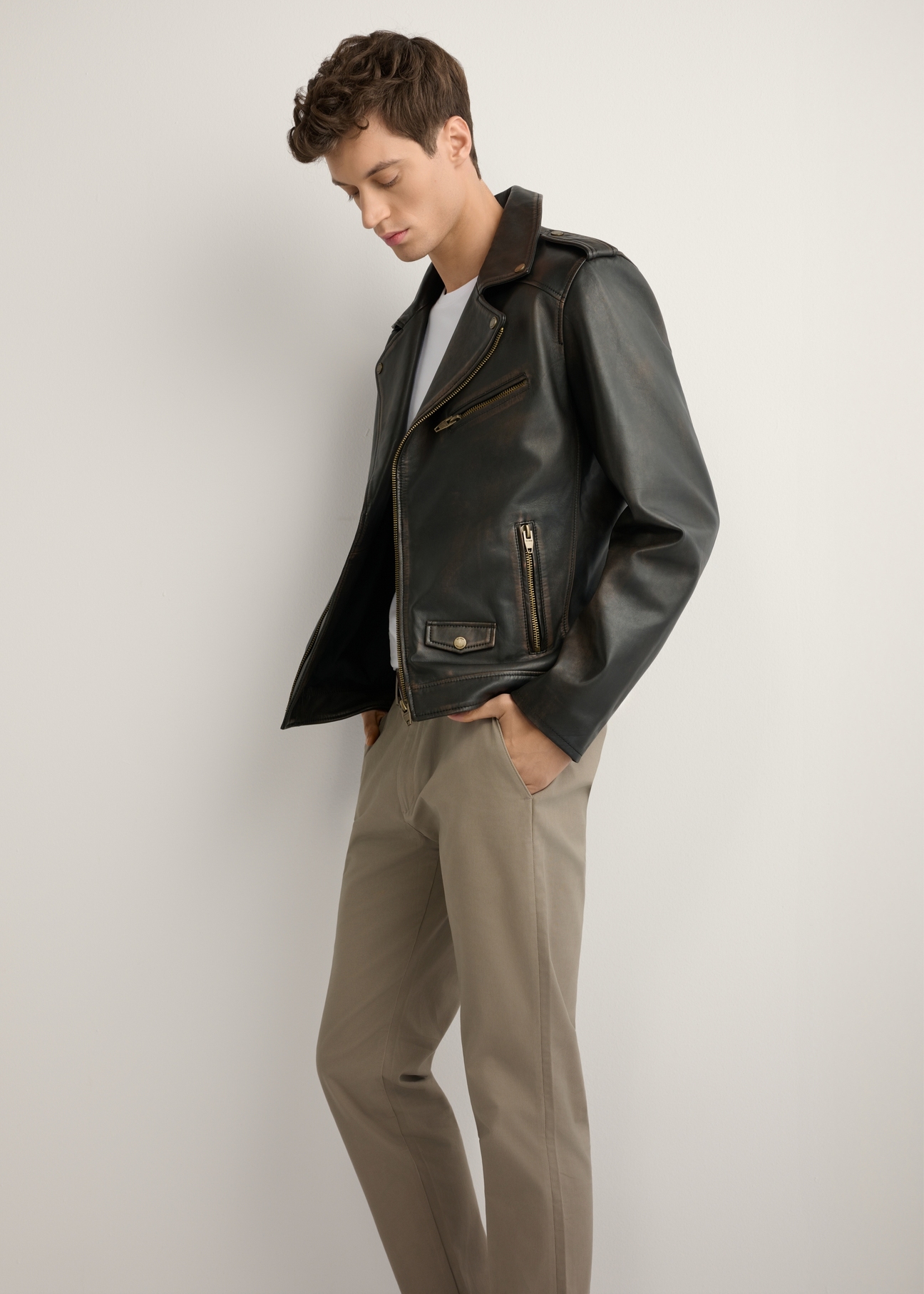 Skórzana kurtka męska ramoneska KURMS-0395-99(W26) - widok produktu z boku, na modelu, na jasnym tle. Widoczna cała sylwetka. 