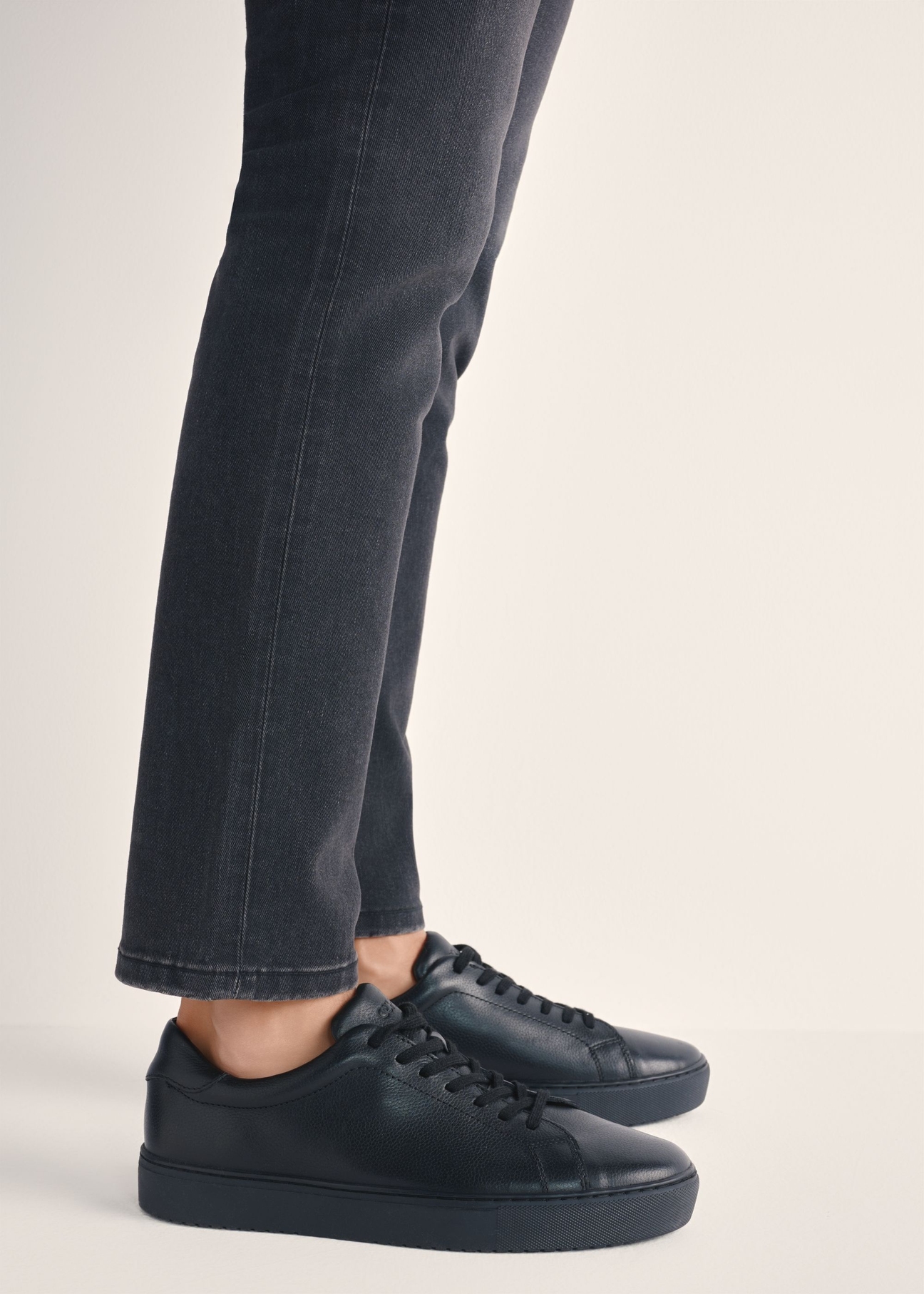 Czarne skórzane buty sportowe BUTYM-0503A-99(W26), widok produktu z boku na stopach modela.