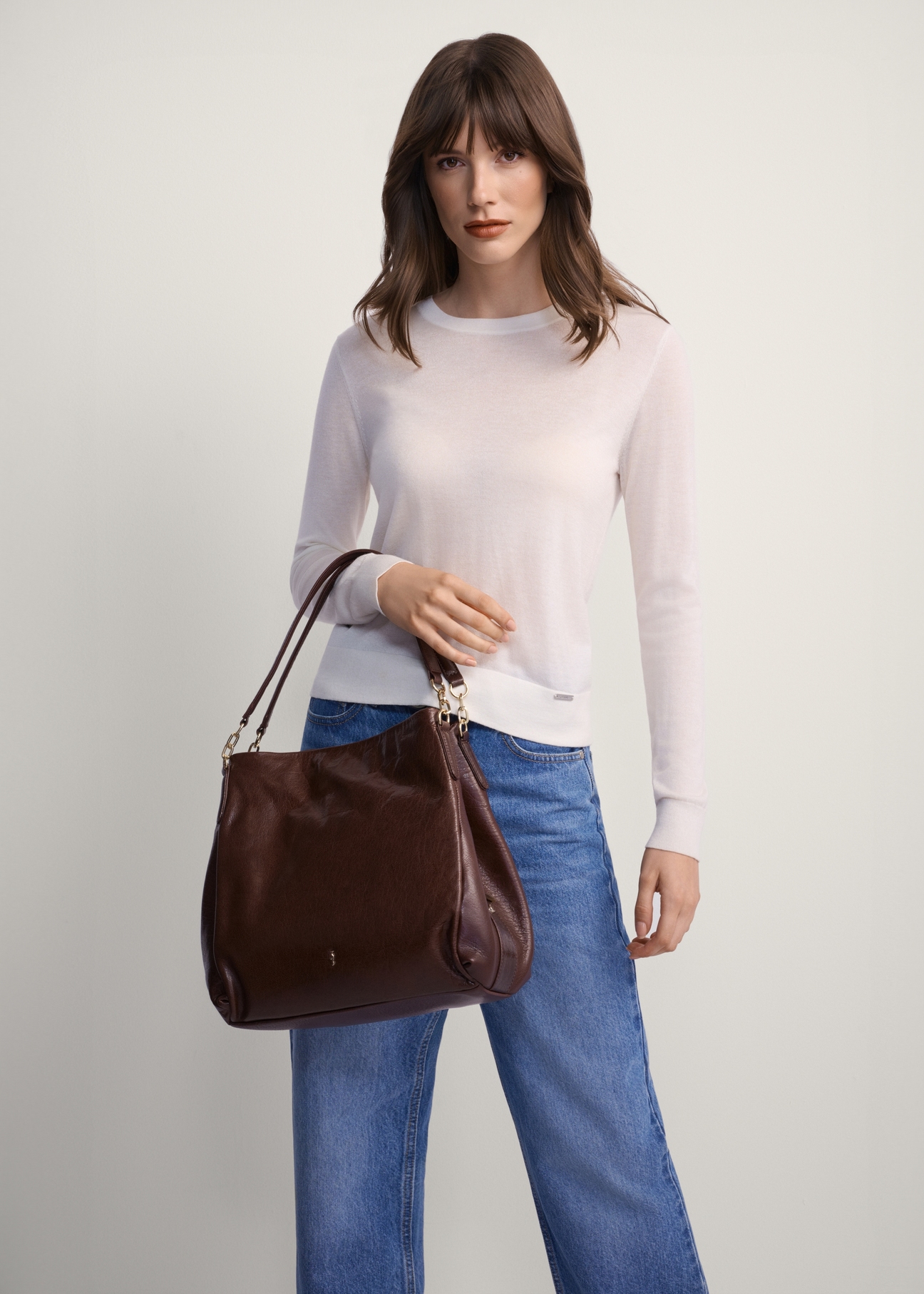 Brązowa skórzana damska torebka shopper TORES-0636D-89(Z25), widok produktu od przodu na modelce, widoczna połowa sylwetki.