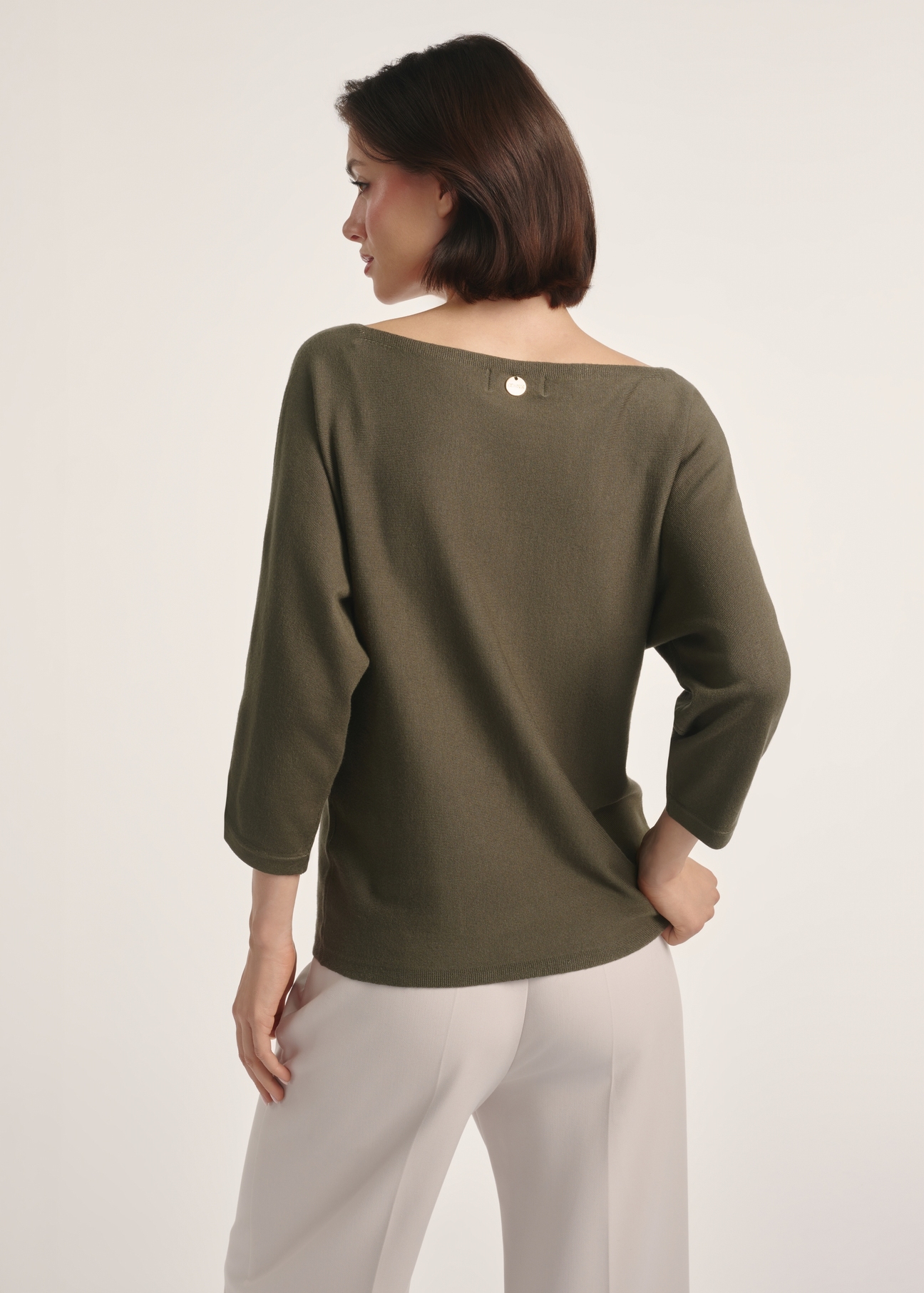 Bluzka damska w kolorze khaki BLUDT-0178-54(Z25), produkt widoczny od tyłu na modelce, widoczne pół sylwetki.