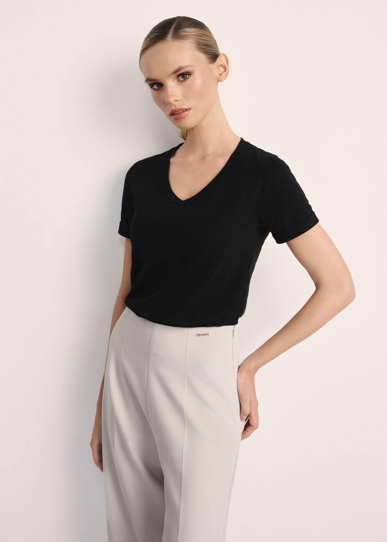 Czarny T-shirt damski w serek TSHDT-0118B-99(Z26), widok produktu z przodu na modelce. Widoczna połowa sylwetki.
