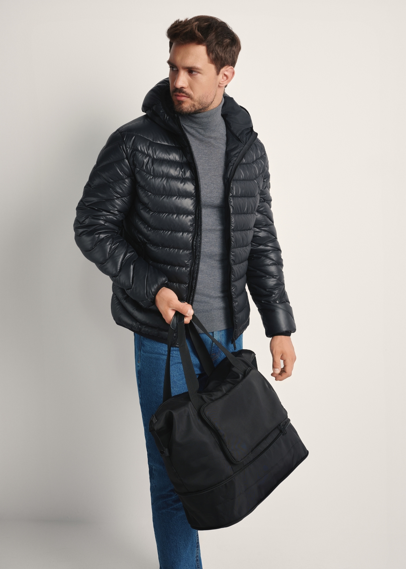 Czarna torba męska TORMN-0369-99(Z25), widok produktu skosem na modelce, widoczna połowa sylwetki.