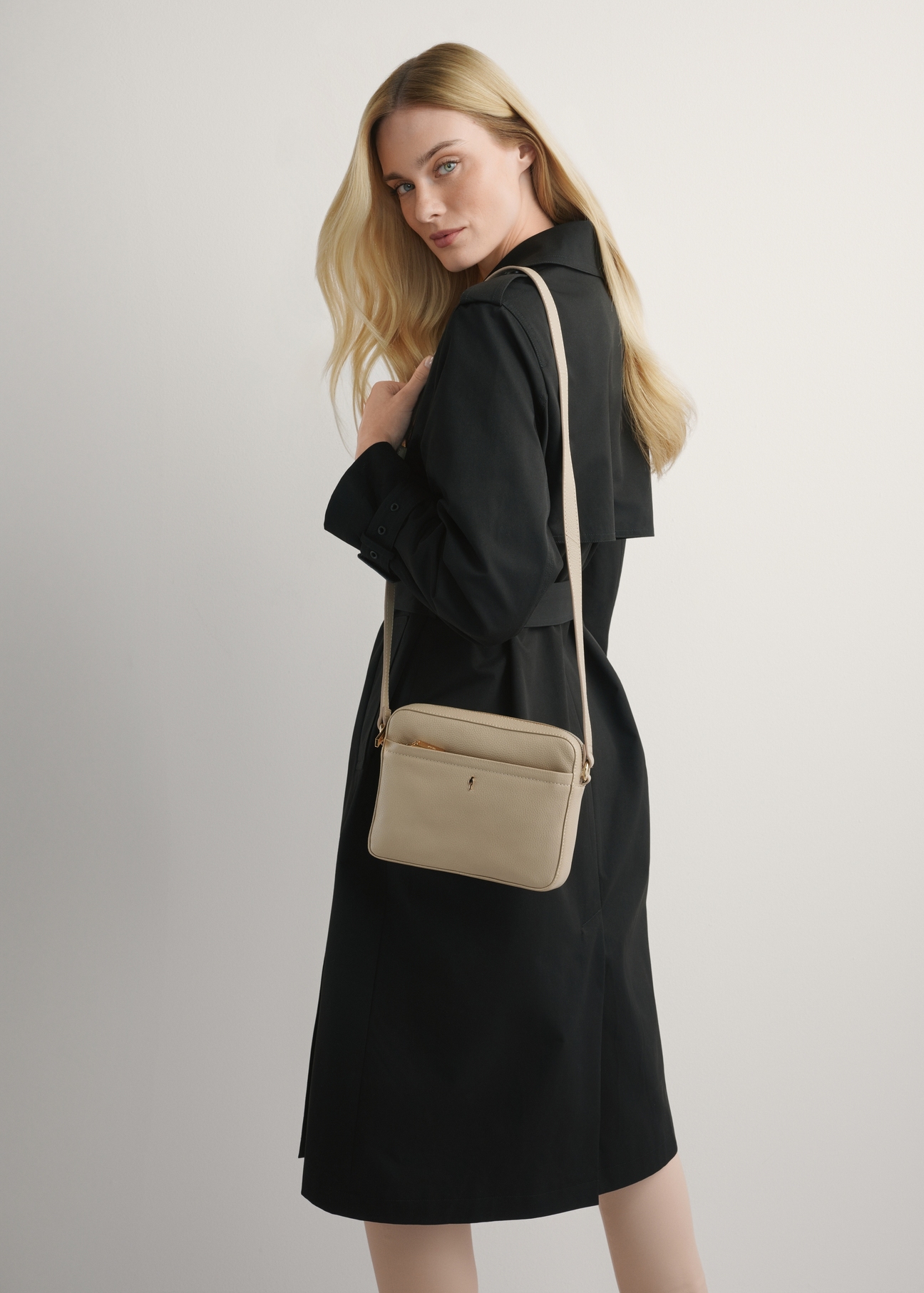 Beżowa mała skórzana torebka damska TORES-1269-1B(W26) - widok produktu z przodu, na modelce, na jasnym tle. 