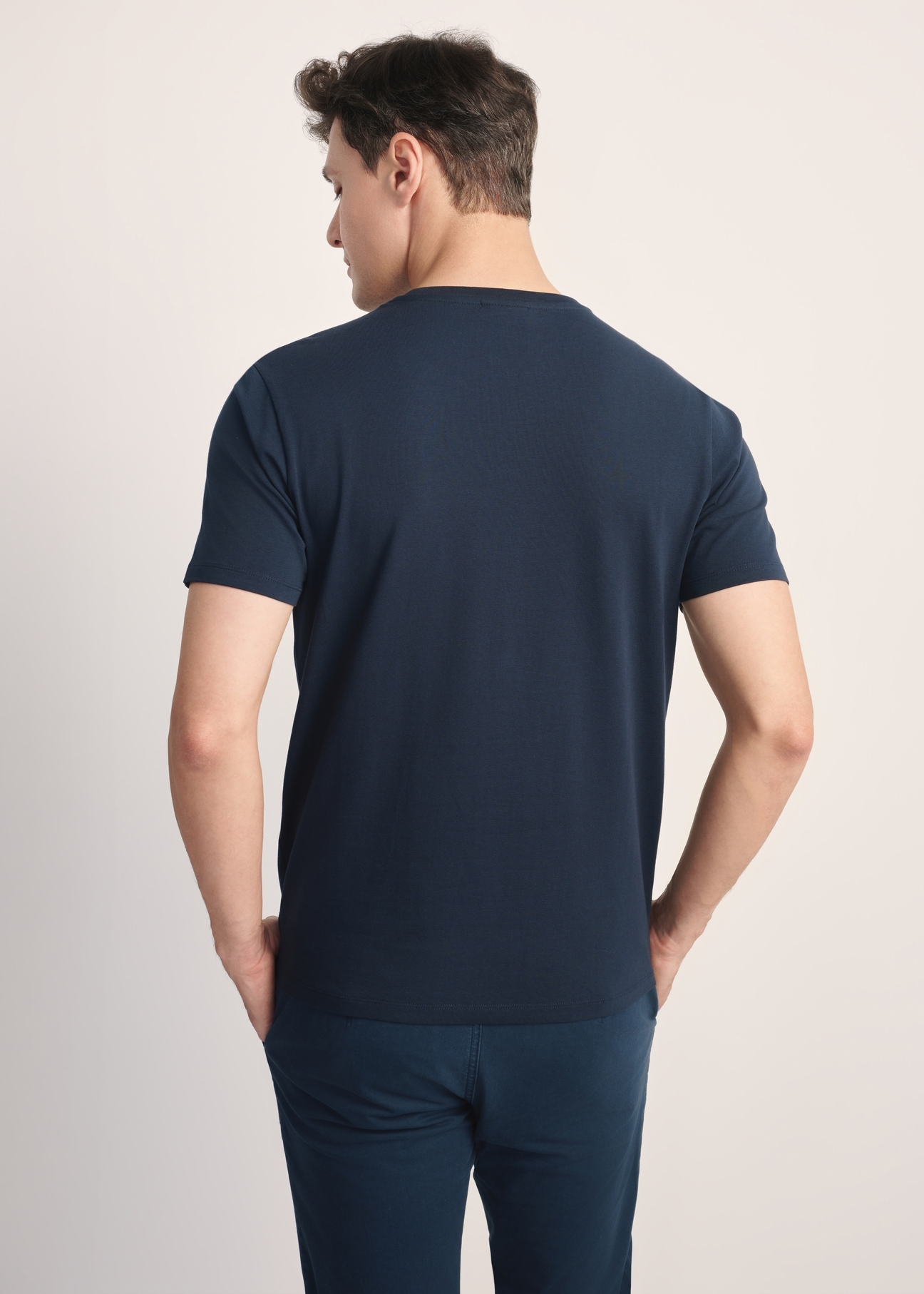 Granatowy bawełniany T-shirt męski TSHMT-0120-69(Z25), widok produktu od tyłu na modelu, widoczna połowa sylwetki.