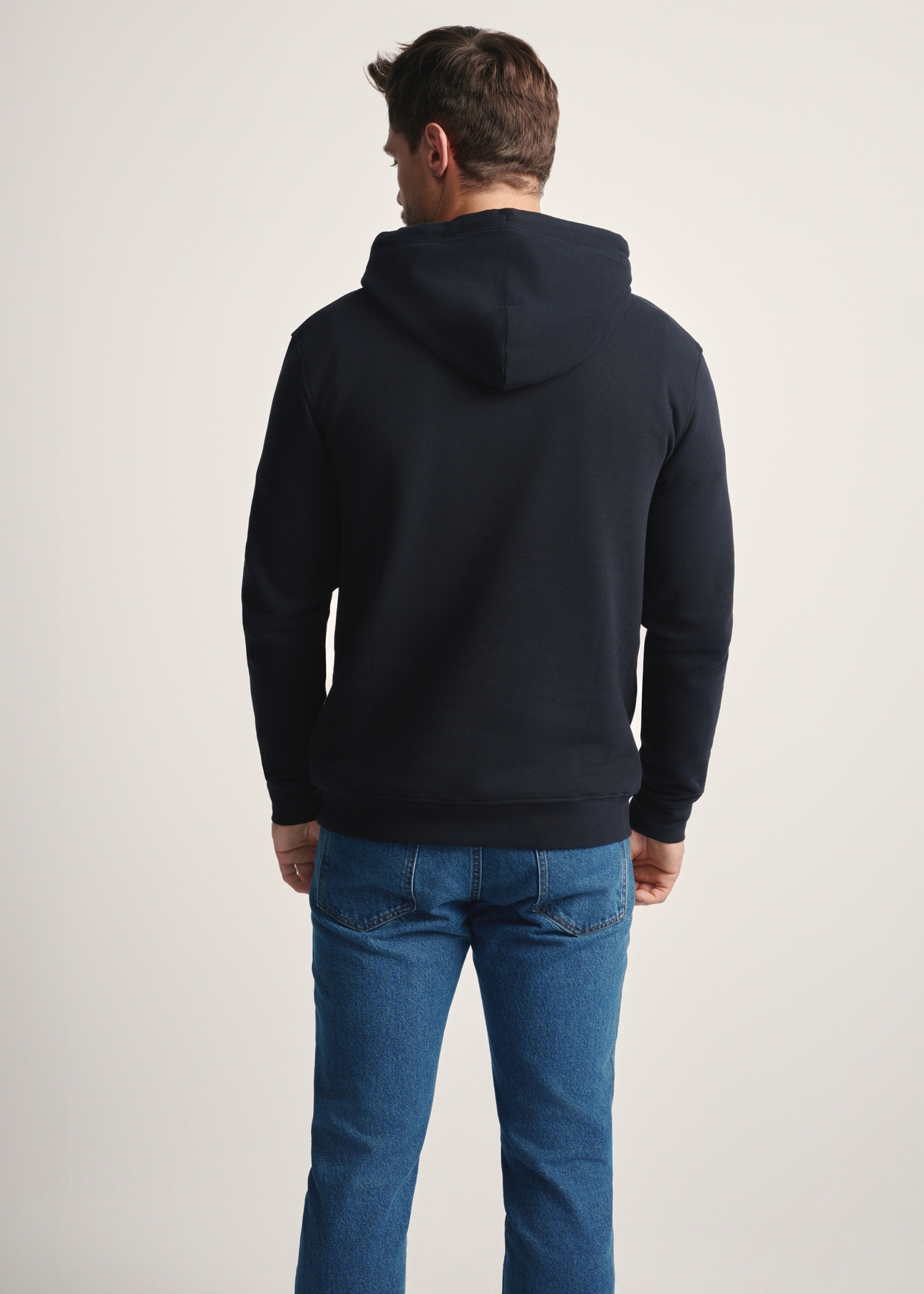 Czarna bluza męska z kapturem BLZMT-0073-99(Z25), widok produktu z tyłu na modelu. Widoczna połowa sylwetki.