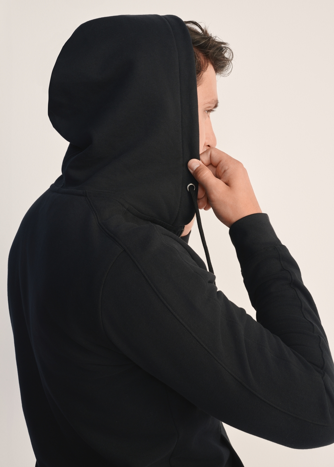 Czarna bluza męska z kapturem BLZMT-0074-99(Z25), zbliżenie na kaptur produktu na modelu. Widoczna górna część sylwetki.