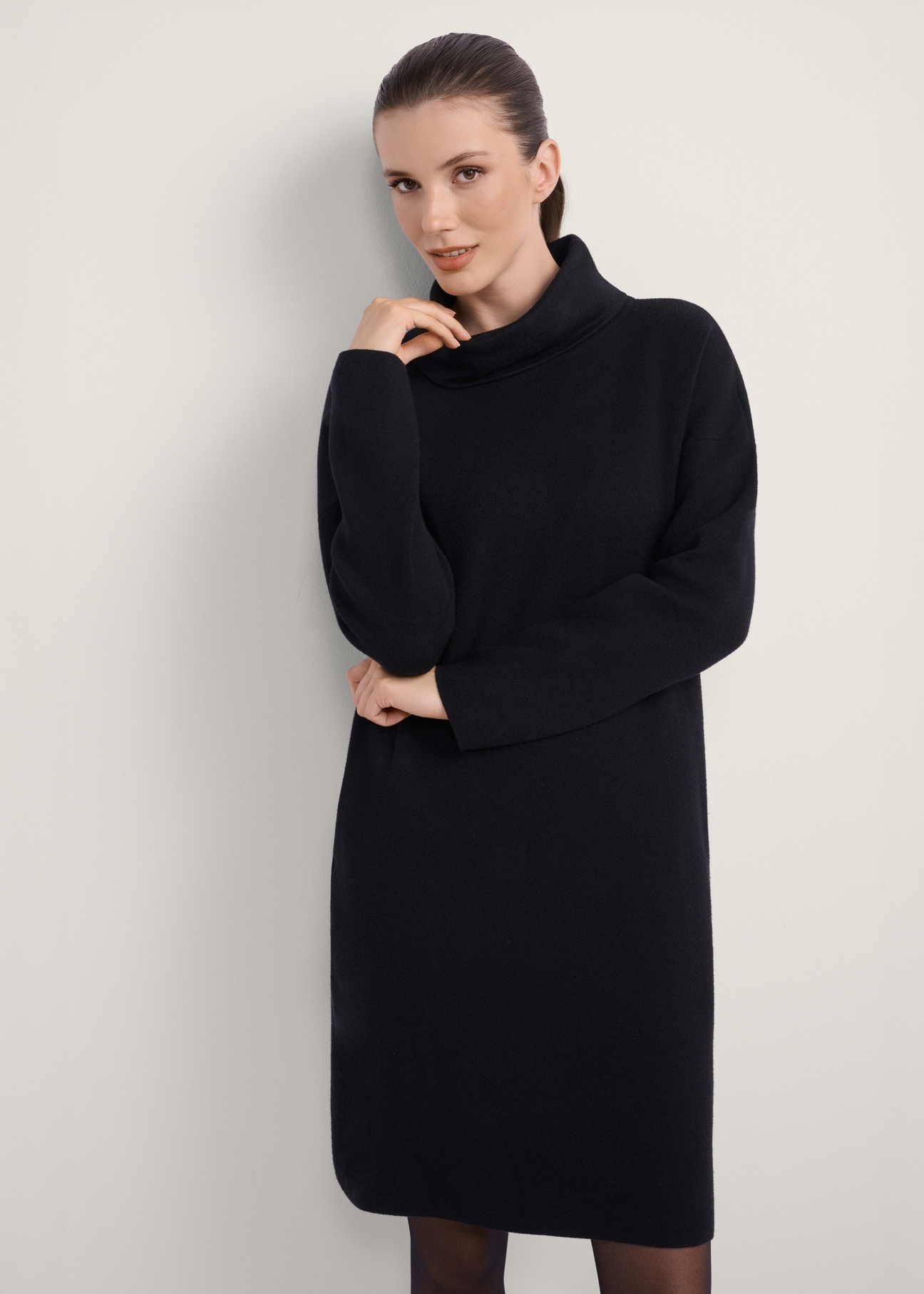 Czarna sukienka z golfem SUKDT-0206A-99(Z25), widok produktu od przodu na modelce, widoczna połowa sylwetki.