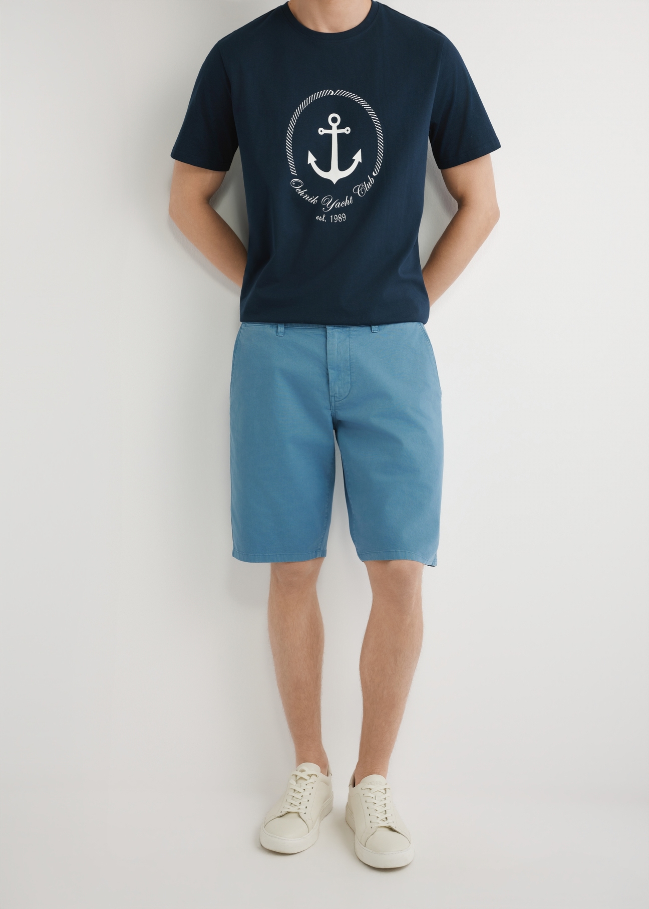 Niebieskie szorty męskie SZOMT-0029-7B(W26), widok produktu z przodu na modelu. Widoczna połowa sylwetki.