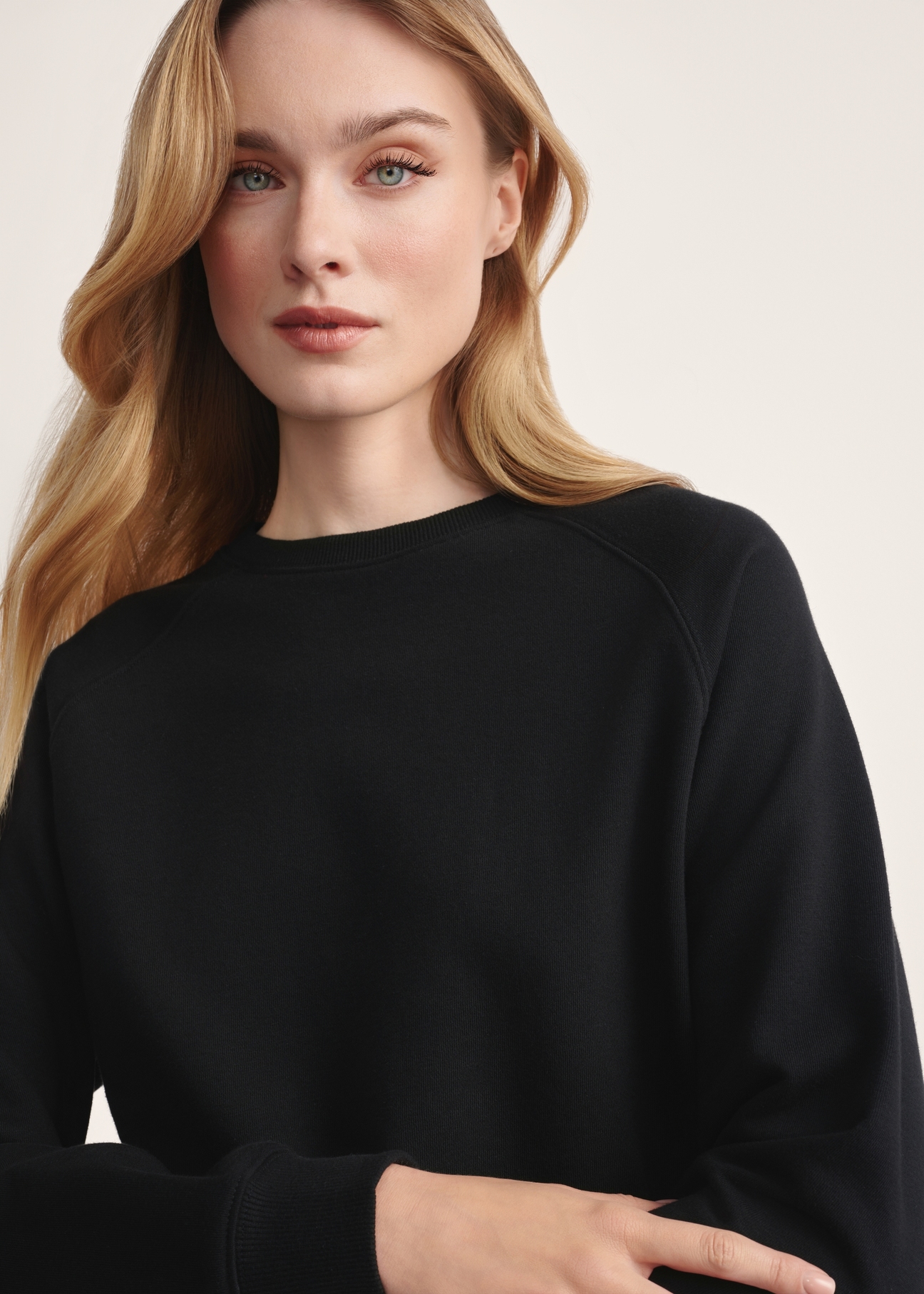 Czarna bluza damska BLZDT-0114-99(Z25), produkt widoczny od przodu na modelce, zbliżenie na detal produktu.