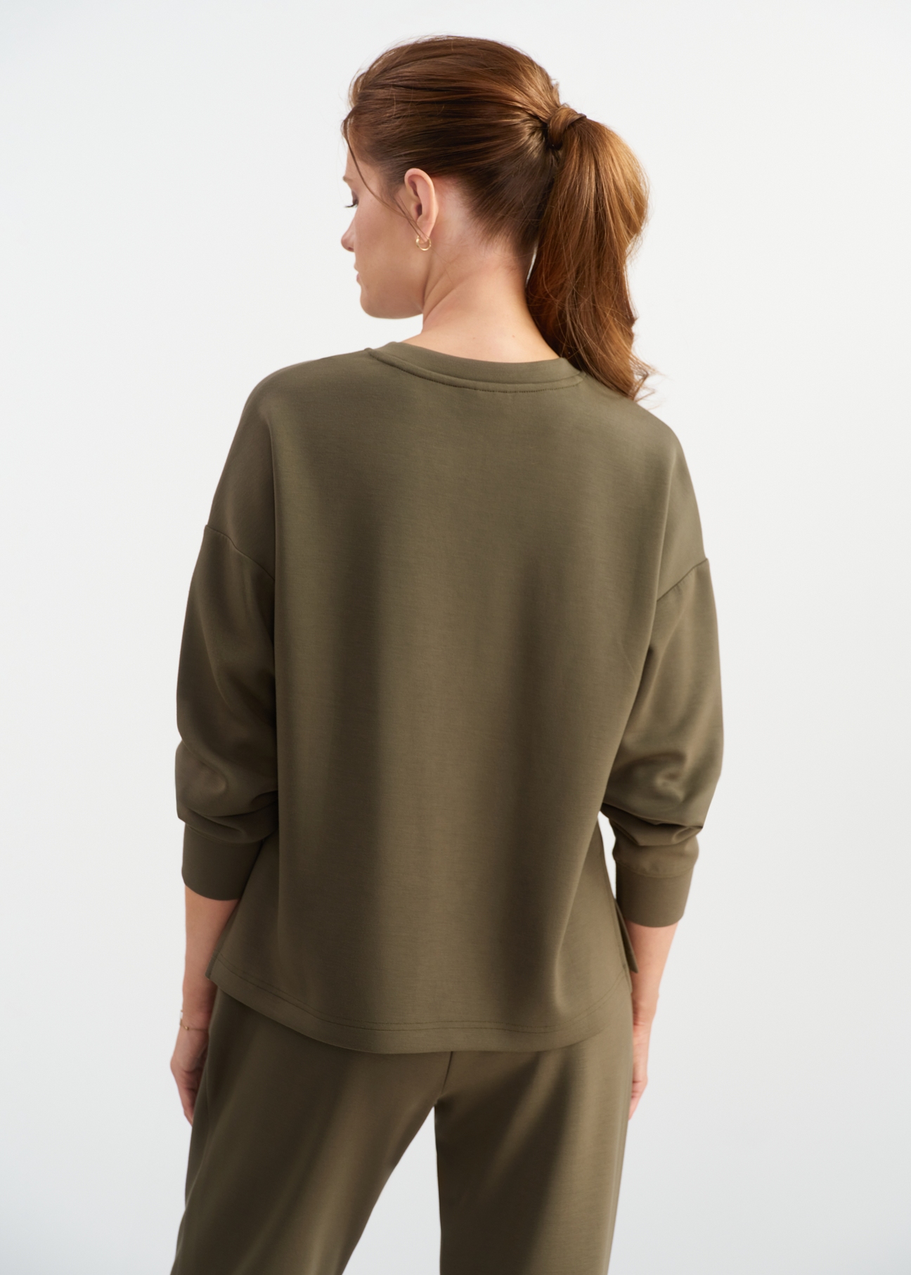 Bluza damska khaki BLZDT-0112-55(W25) - widok z tyłu na modelce, na białym tle. Widoczna cała sylwetka do połowy.