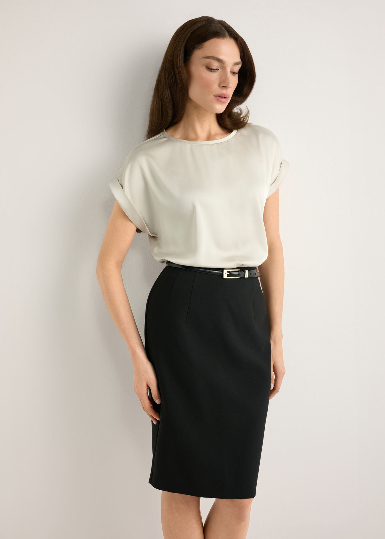 Jasnobeżowa bluzka damska BLUDT-0205-1A(W26), widok produktu z przodu na modelce. Widoczna połowa sylwetki.