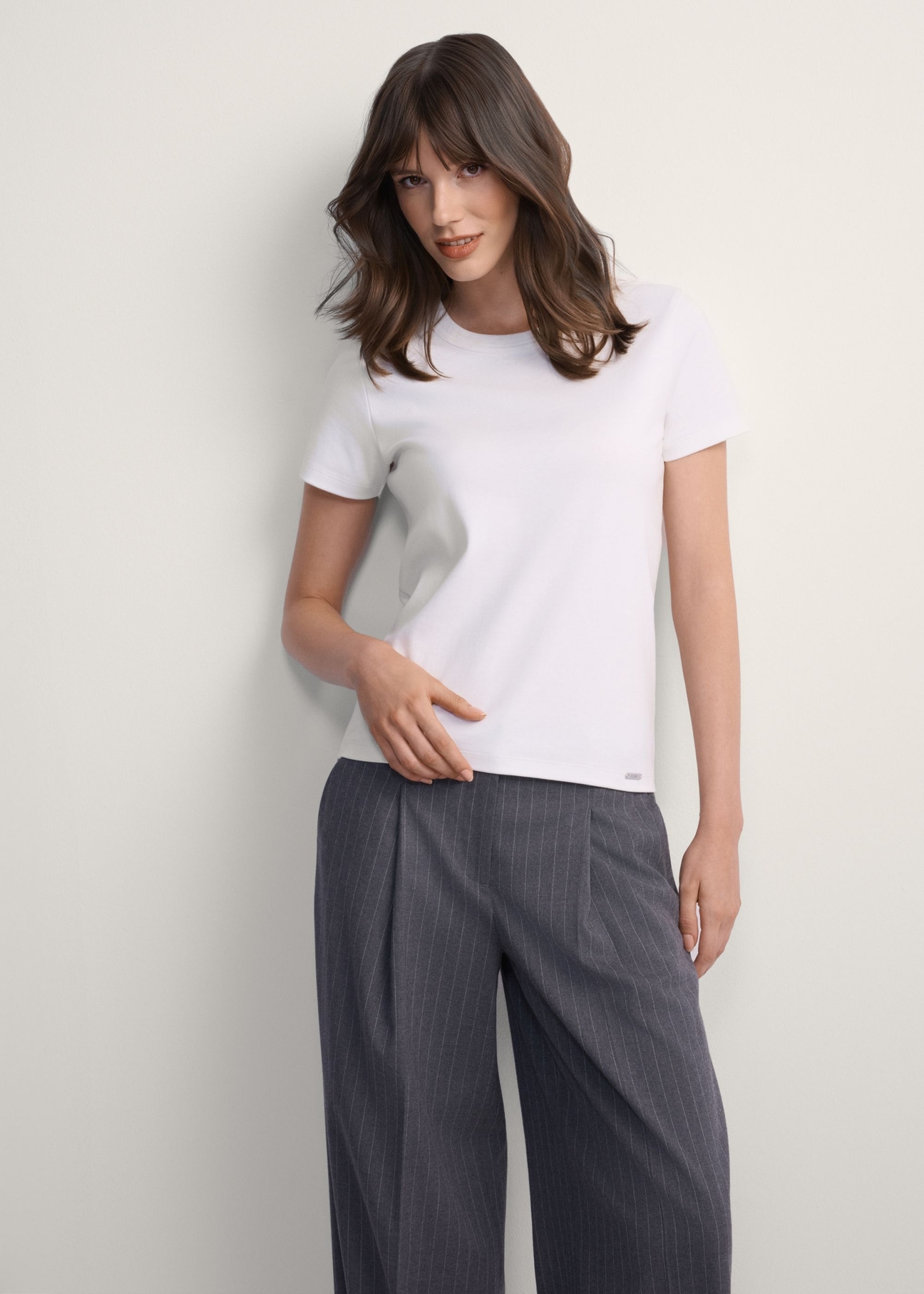 Biały bawełniany t-shirt damski TSHDT-0144-0B(Z26), widok produktu od przodu na modelce, widoczna połowa sylwetki.