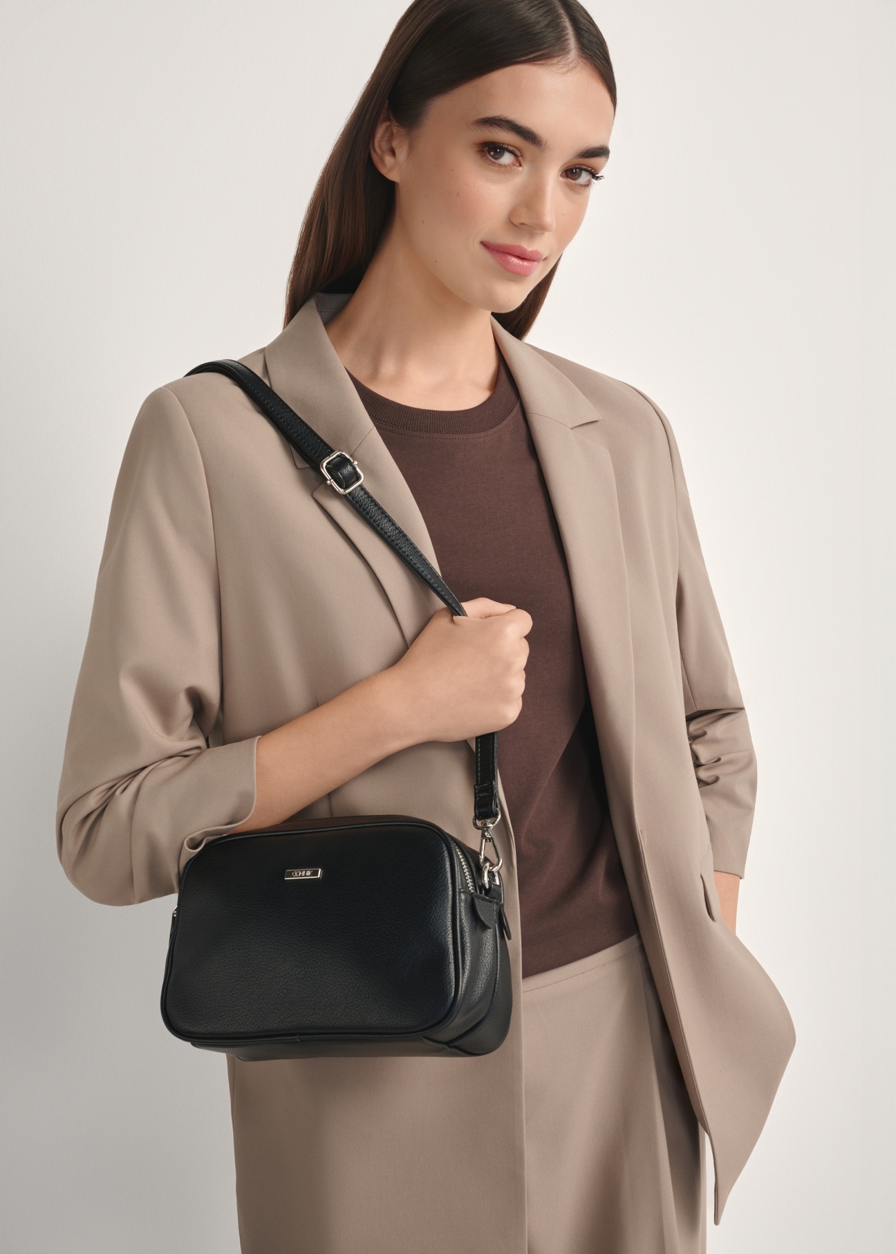 Czarna średnia torebka damska TOREC-1121-9I(W26), widok produktu od przodu na modelce, widoczna połowa sylwetki.