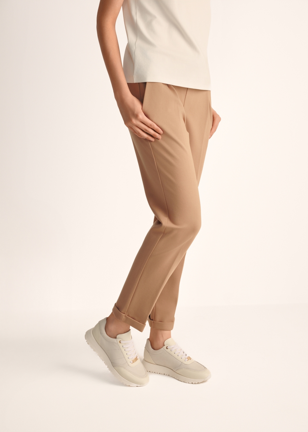 Kremowe skórzane buty sportowe damskie BUTYD-1099-11(Z25), widok produktu na stopach modelki na jasnym tle.