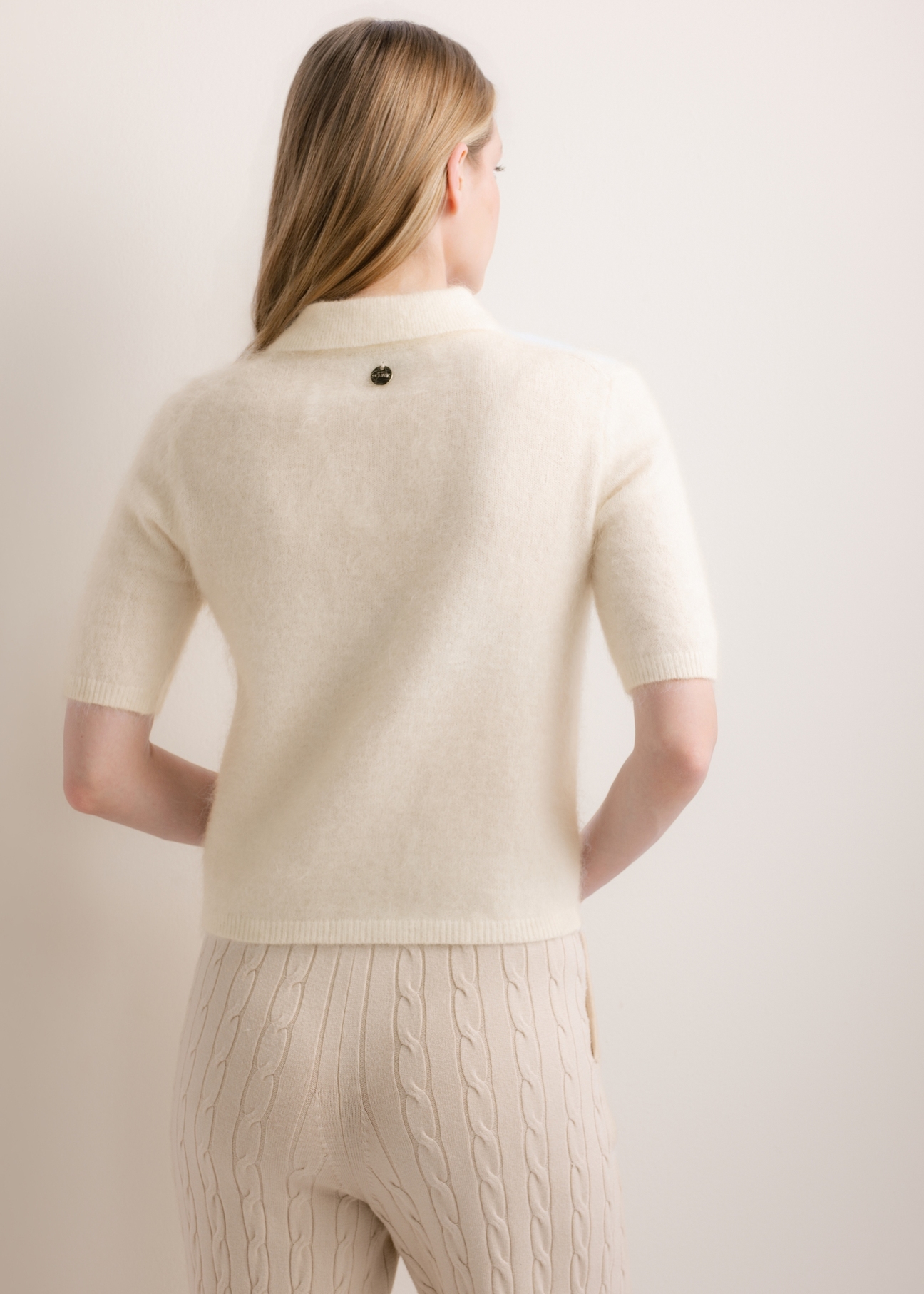 Kremowy cienki sweter polo z dzianiny BLUDT-0221-0B(Z26), widok produktu z tyłu na modelce. Widoczna połowa sylwetki.