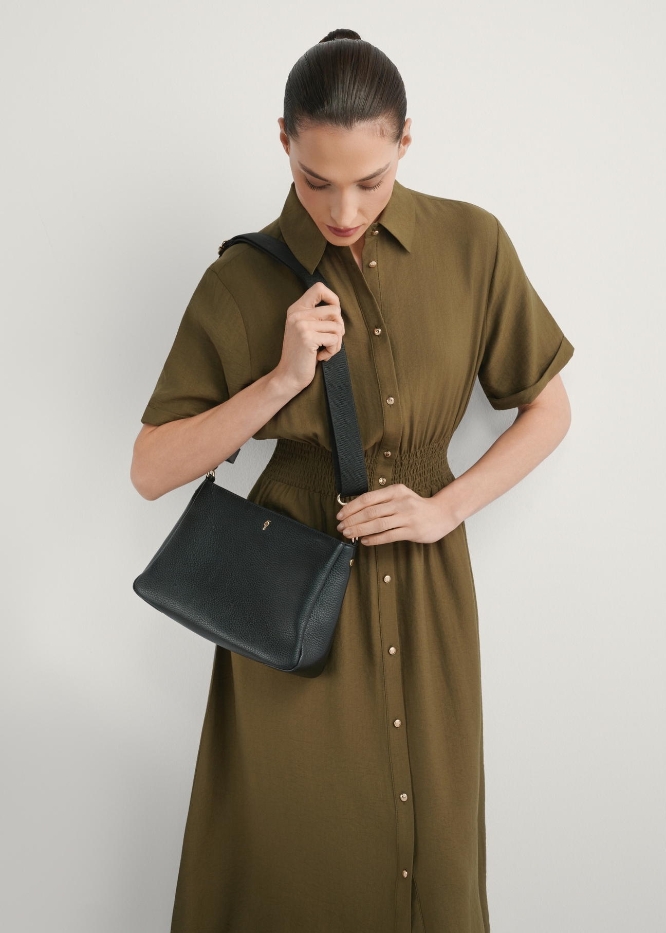 Czarna skórzana listonoszka damska TORES-1214-9I(W26), widok produktu od przodu na modelce, widoczna połowa sylwetki.