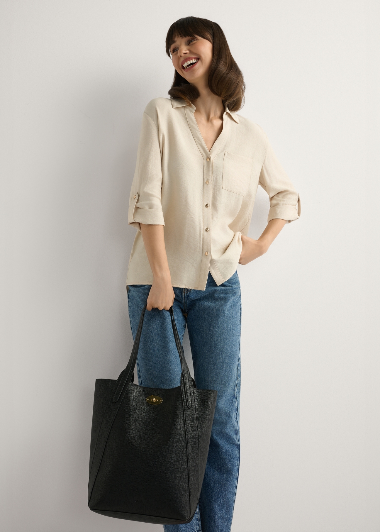 Czarna duża torebka damska shopper TOREC-1142-9I(W26), widok produktu w dłoni modelki. Widoczna cała sylwetka.