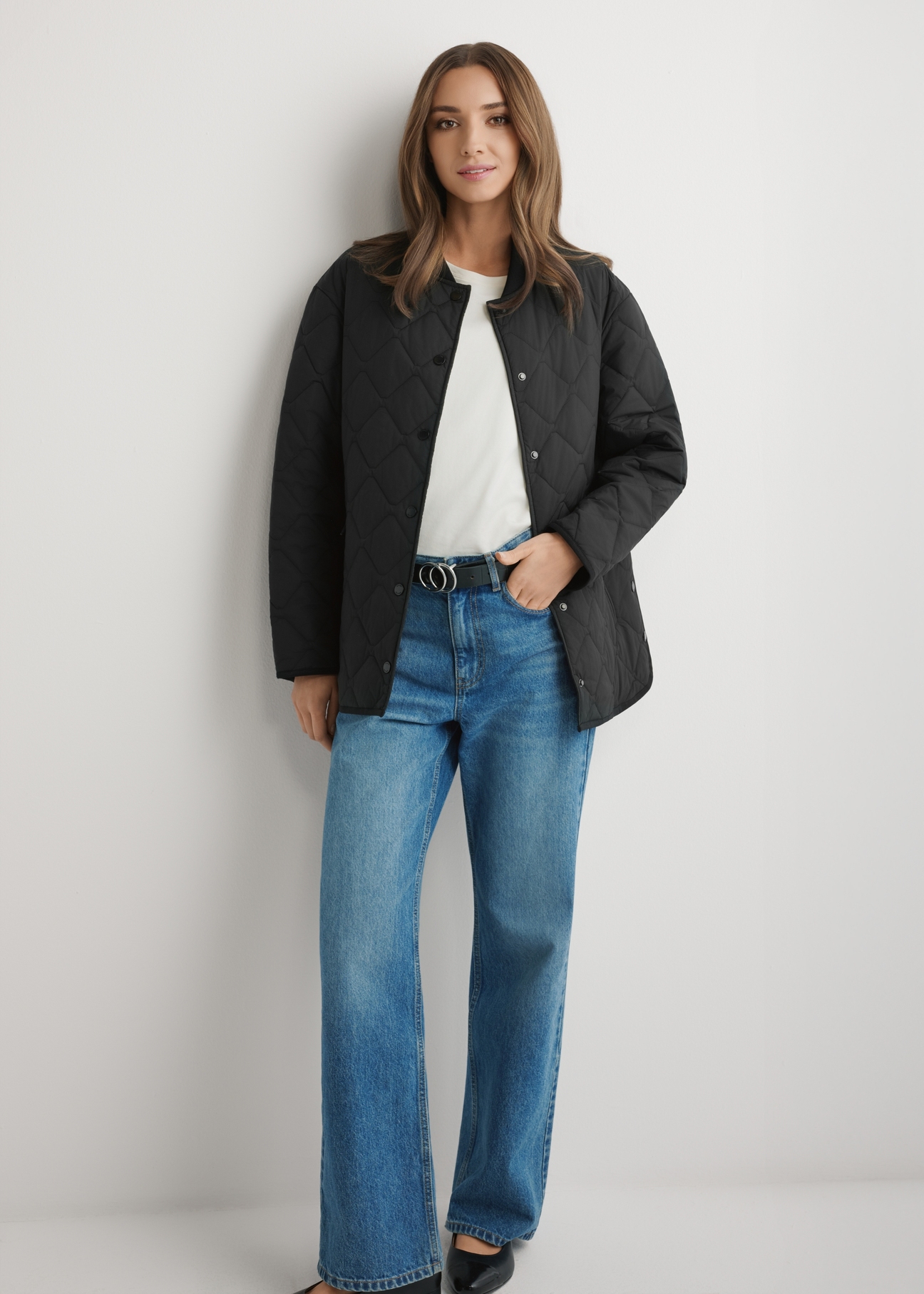 Czarna pikowana kurtka damska KURDT-0580-99(W26) - widok produktu z przodu, na modelce, na jasnym tle. Widoczna cała sylwetka.