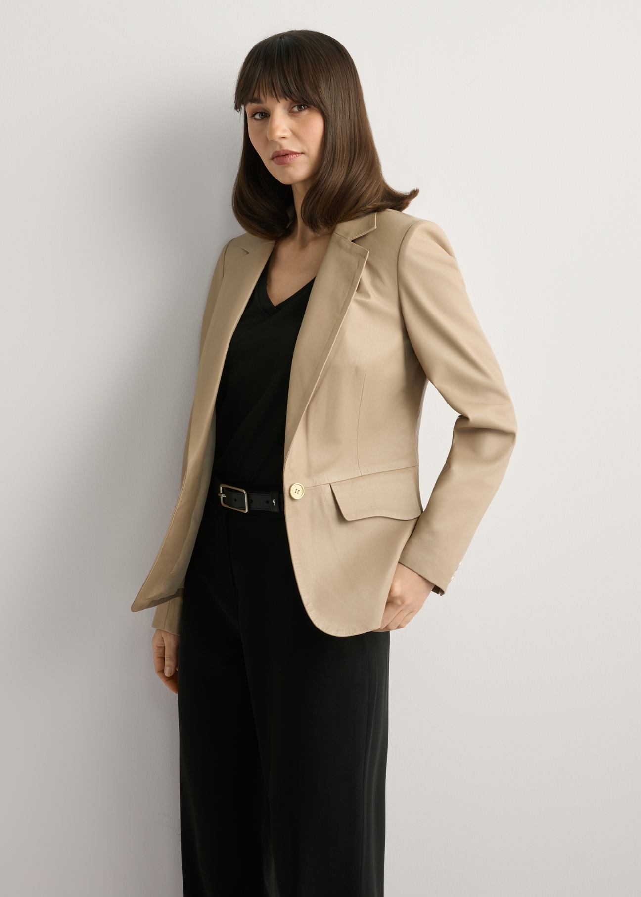 Beżowa skórzana marynarka damska KURDS-0445-1B(W26), widok produktu z przodu na modelce. Widoczna połowa sylwetki.