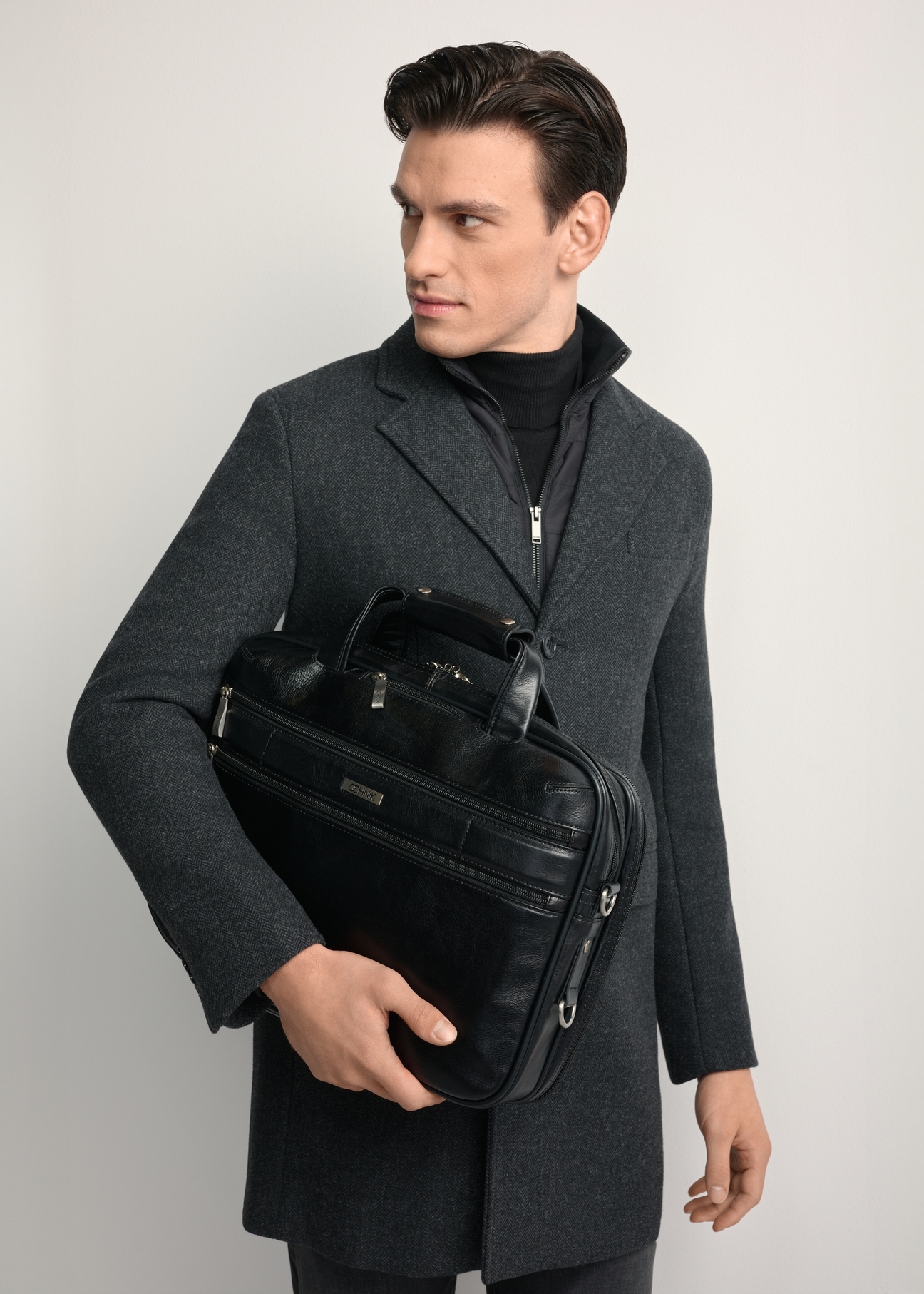 Czarna skórzana torba męska TORMS-0483-99(Z25) - widok produktu z przodu, na modelu, na białym tle. Widoczna połowa sylwetki. 