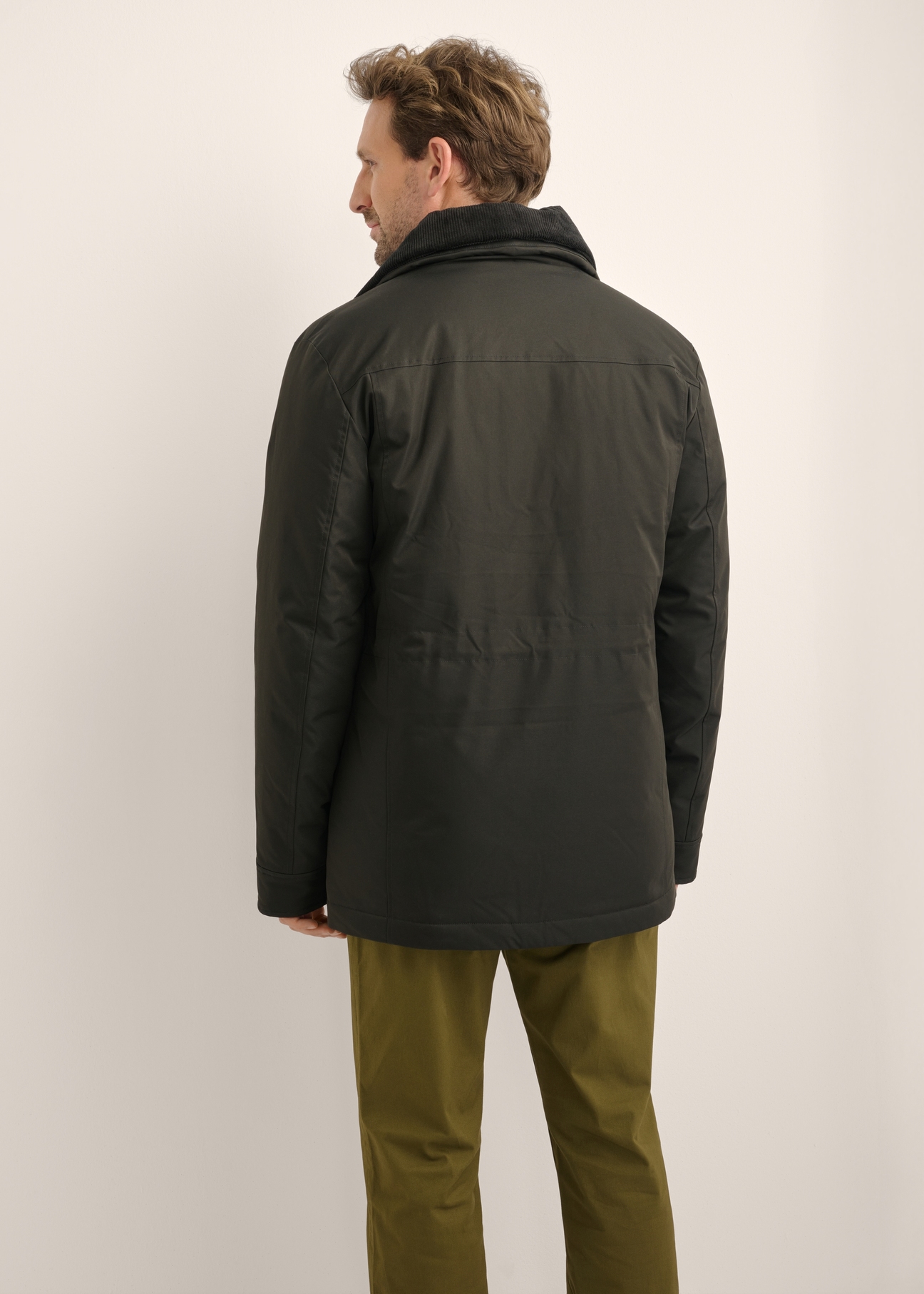 Czarna kurtka męska KURMT-0442-99(Z26), widok produktu z tyłu na modelu. Widoczna połowa sylwetki.