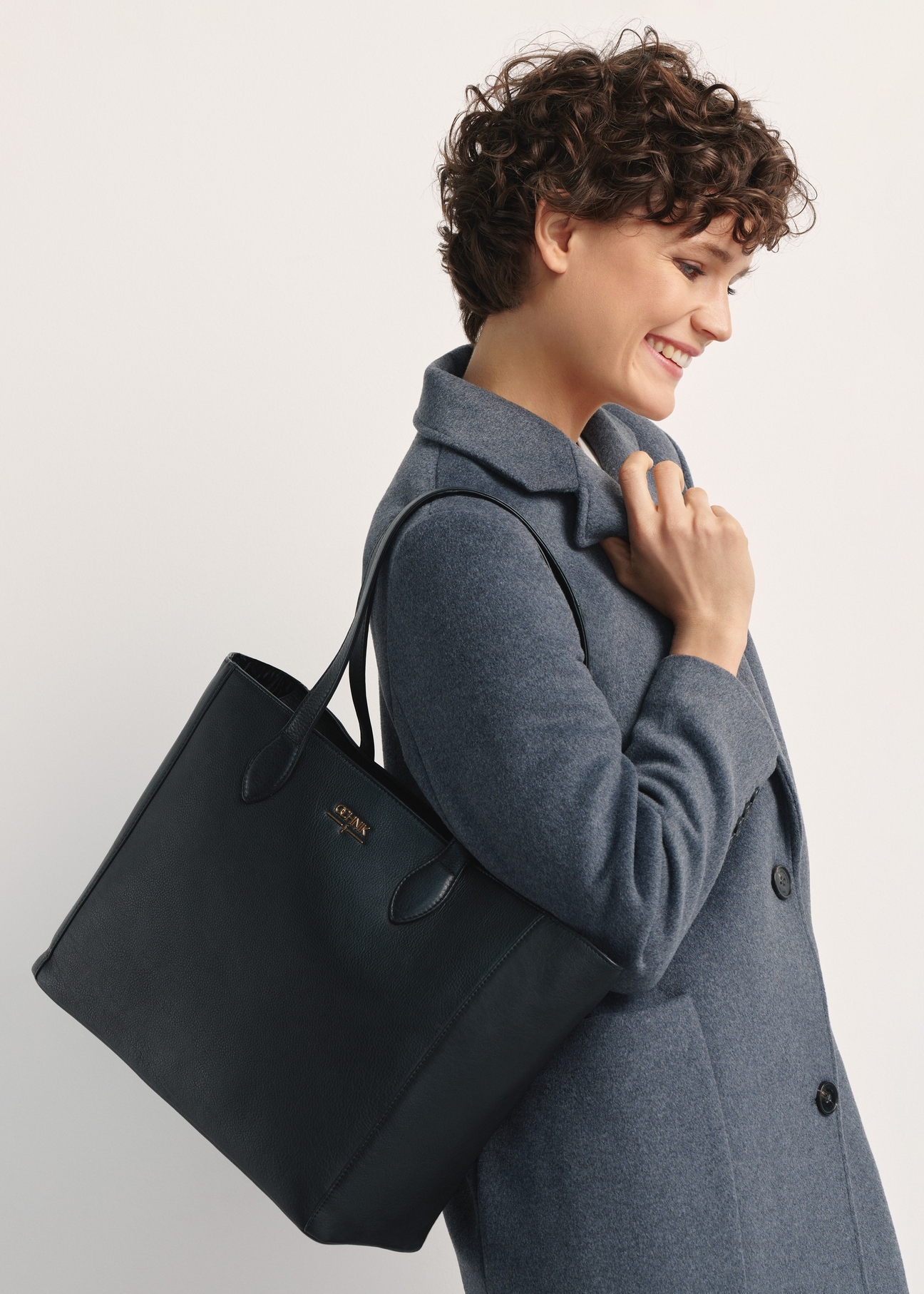 Czarna skórzana torebka shopper damska TORES-0971F-99(W26), widok produktu od przodu na modelce, widoczna połowa sylwetki.