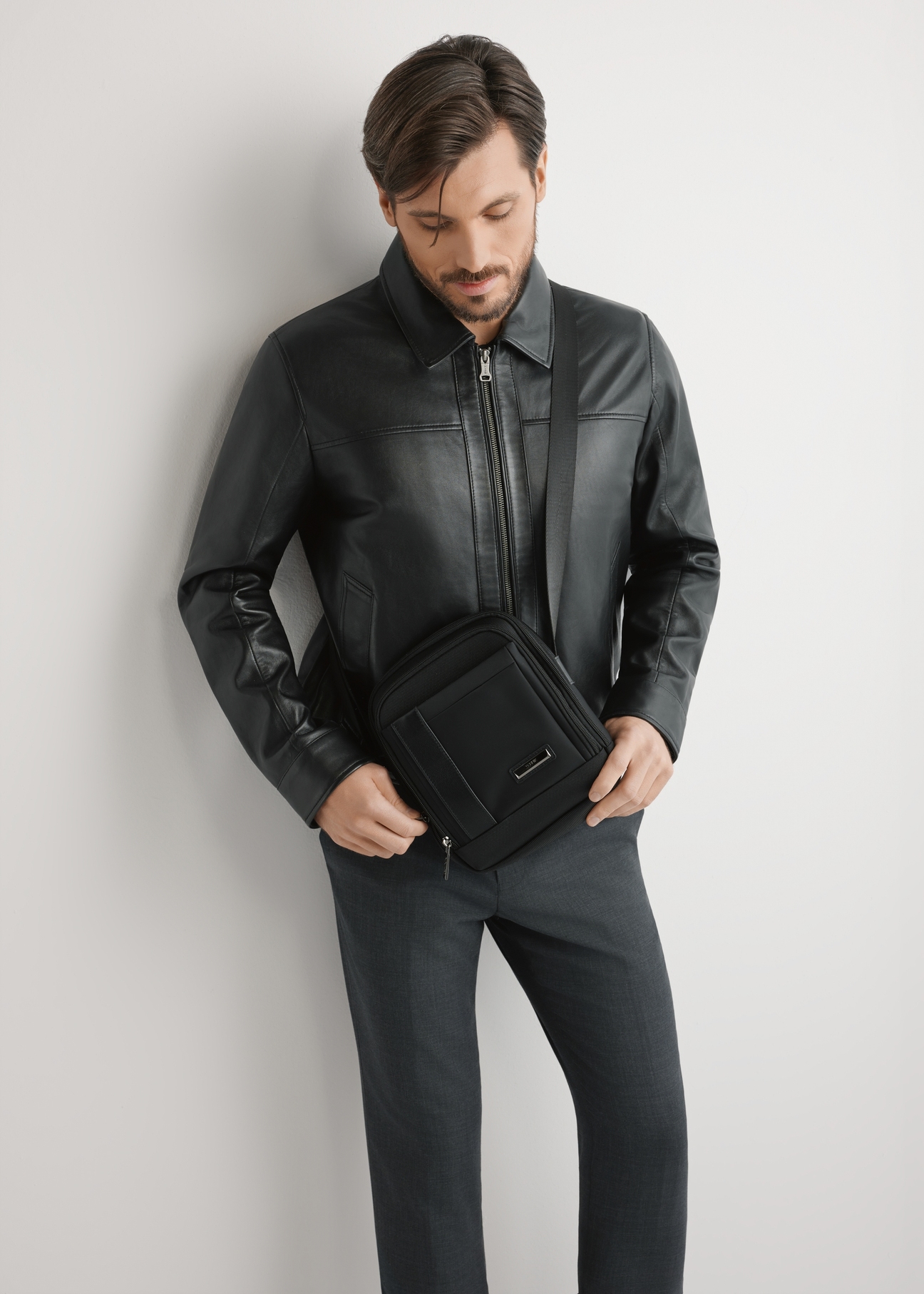 Czarna saszetka męska TORMN-0404-99(W26), widok produktu na sylwetce modela, na jasnym tle.