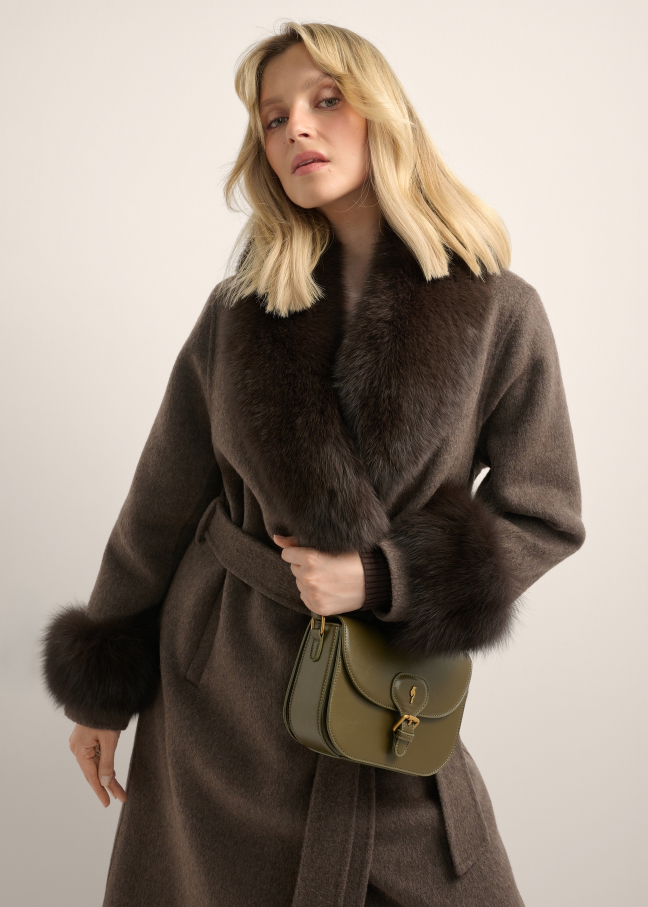 Mała khaki listonoszka damska z ozdobnym zapięciem TOREC-1243-8D(Z26), widok produktu skosem na modelce. Widoczna połowa sylwetki.