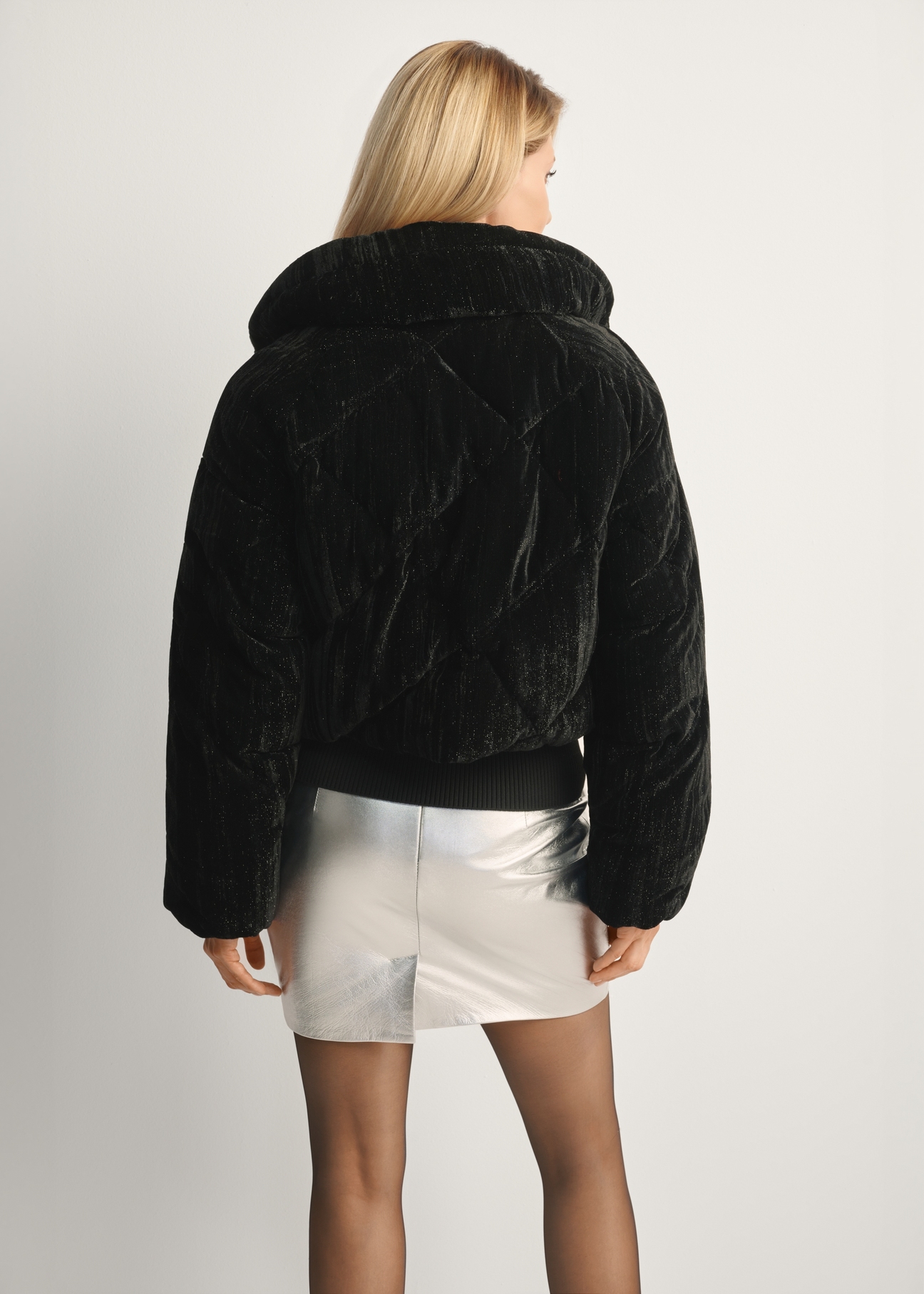 Krótka błyszcząca kurtka damska KURDT-0607-99(Z25), widok produktu tyłem na modelce, widoczna połowa sylwetki.