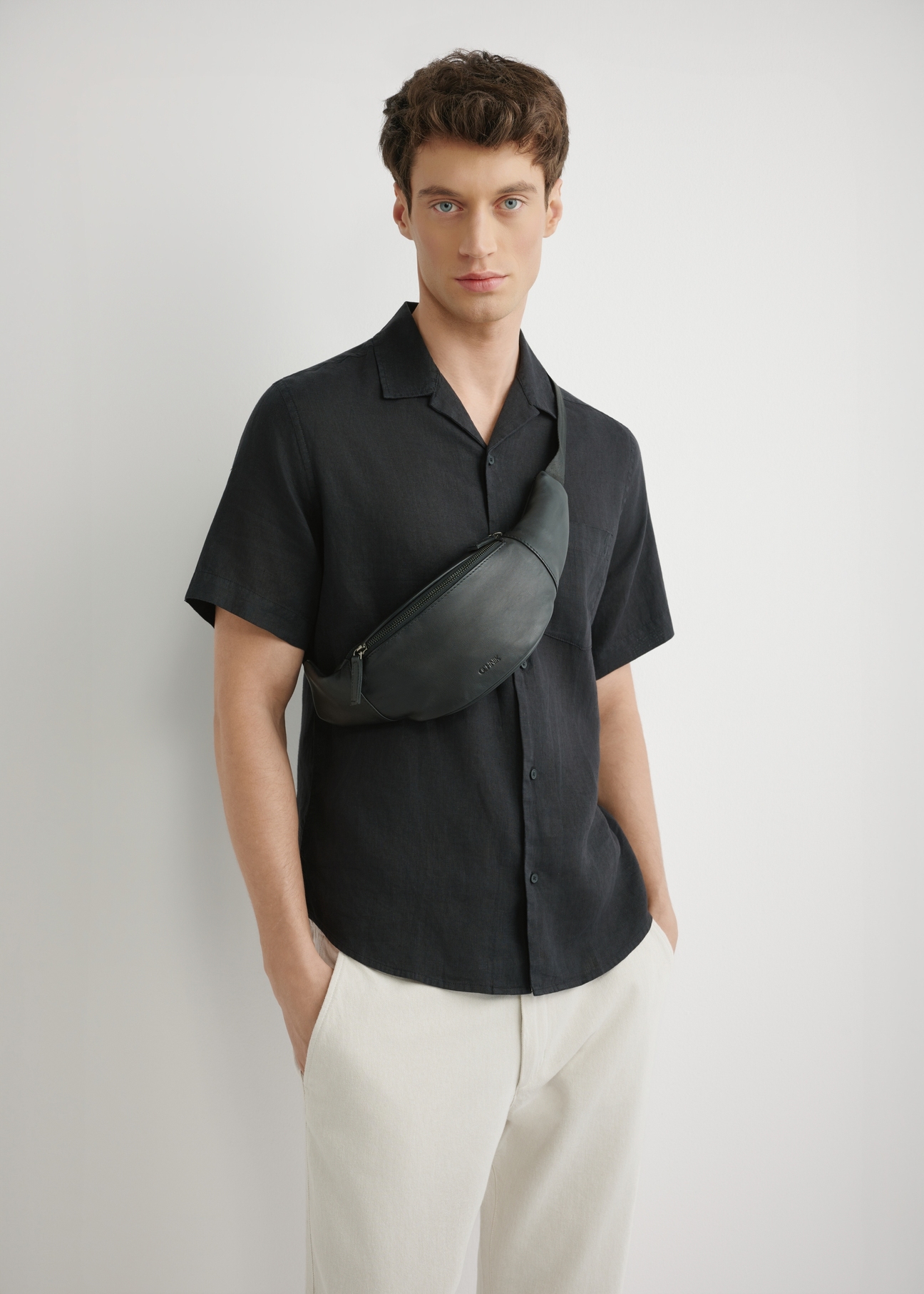 Czarna skórzana nerka męska TORMS-0497-99(W26), widok produktu z przodu na sylwetce modela.