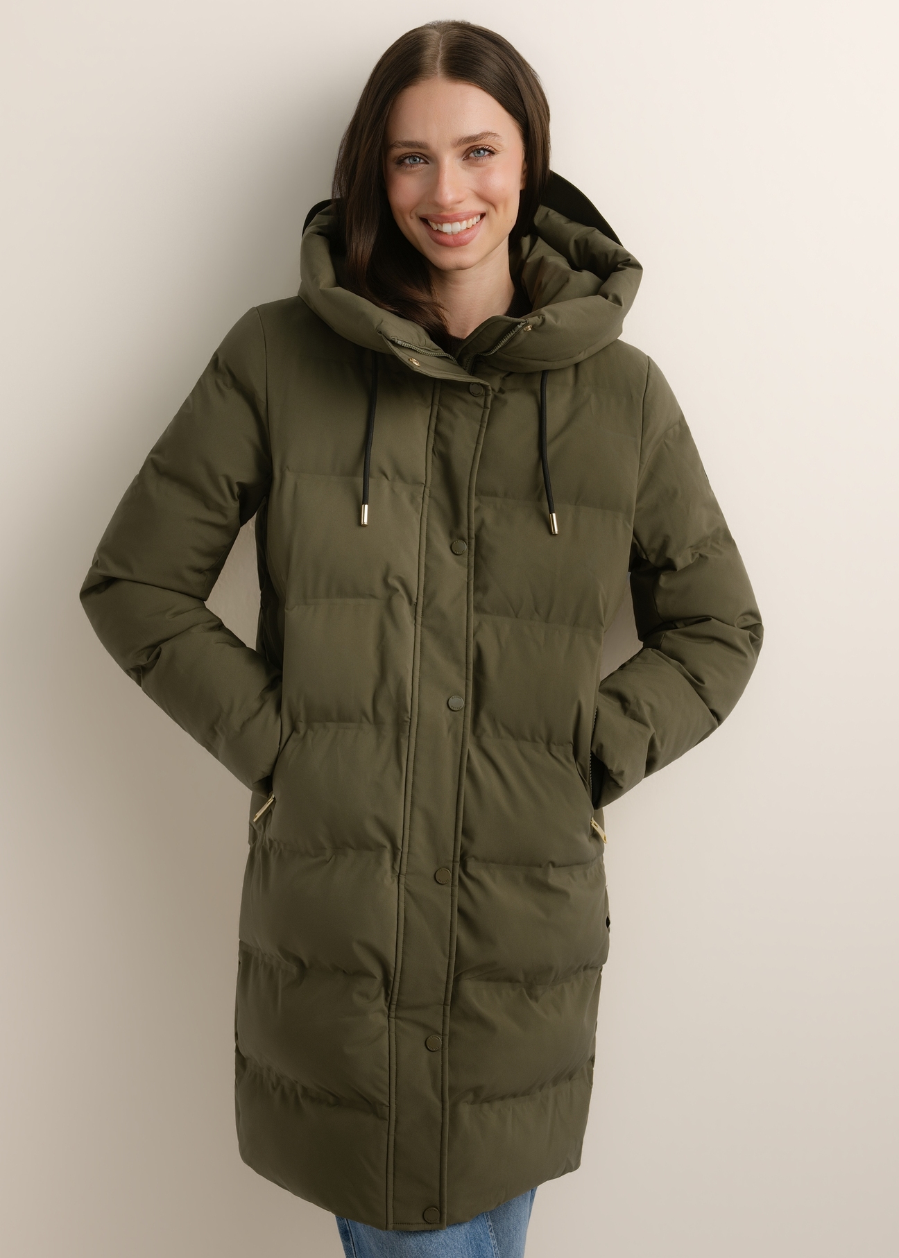 Zimowa kurtka damska w kolorze khaki KURDT-0700-8D(Z26), widok produktu z przodu na modelce. Widoczna połowa sylwetki.